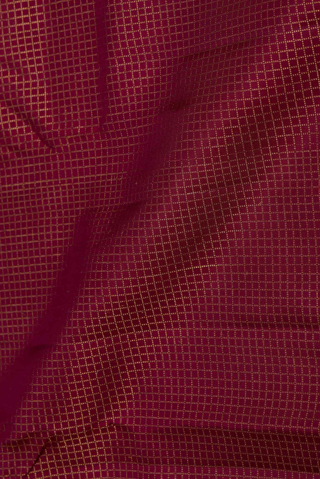 Close up of Maroon Dual Tone Kanchipuram Saree with Checked design on the body and Zari Border displaying folds