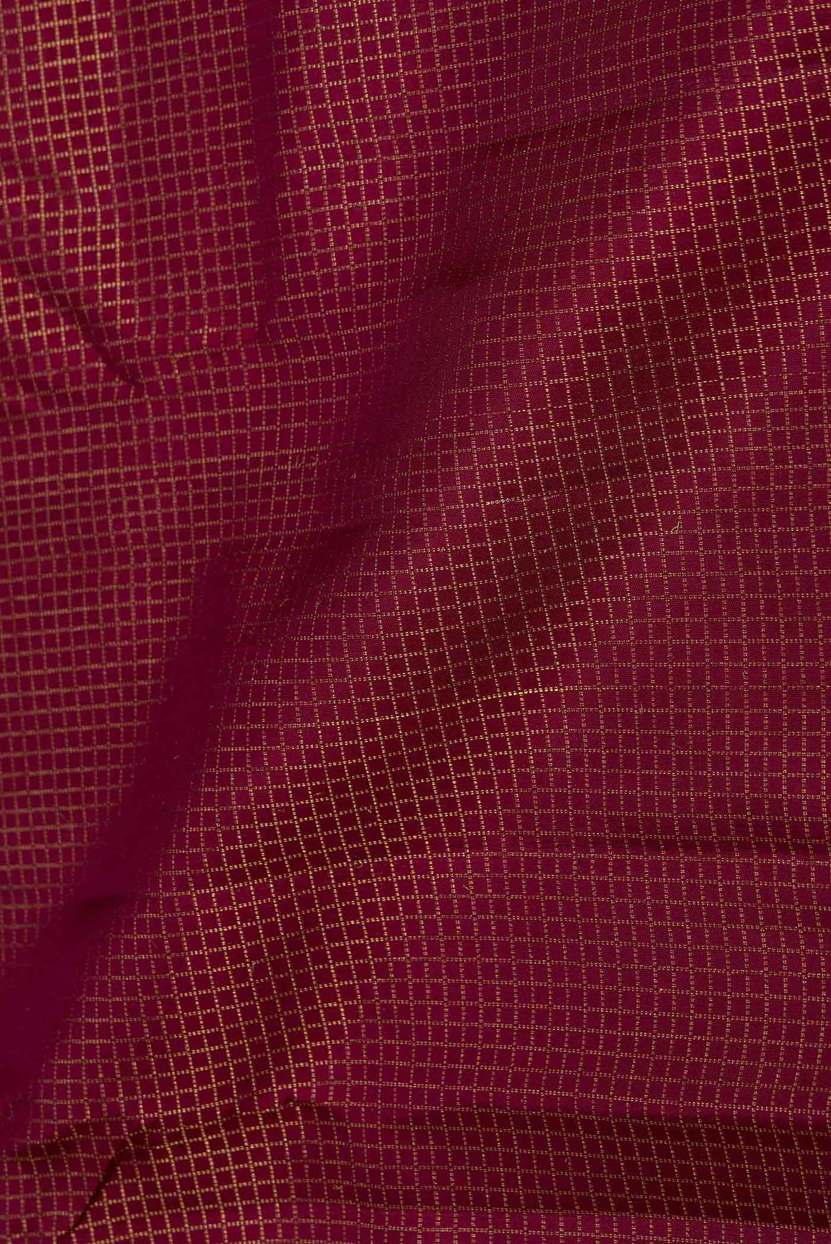 Close up of Maroon Dual Tone Kanchipuram Saree with Checked design on the body and Zari Border displaying folds