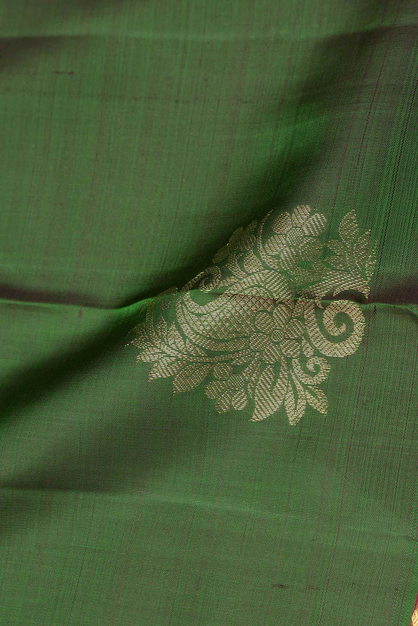 Close up of Green Dual Tone Kanchipuram Saree with Zari Butta on the body and Zari Border.  displaying folds