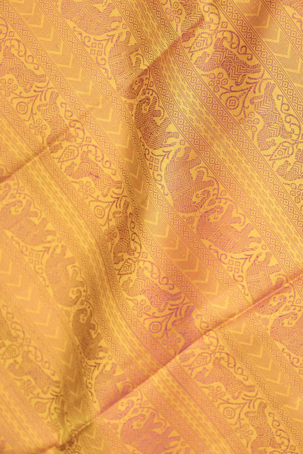 Close up of Pure Silk Pure Zari Mustard Dual Tone Kanchipuram Saree with Jacquard design on the body and Zari And Thread Border displaying folds
