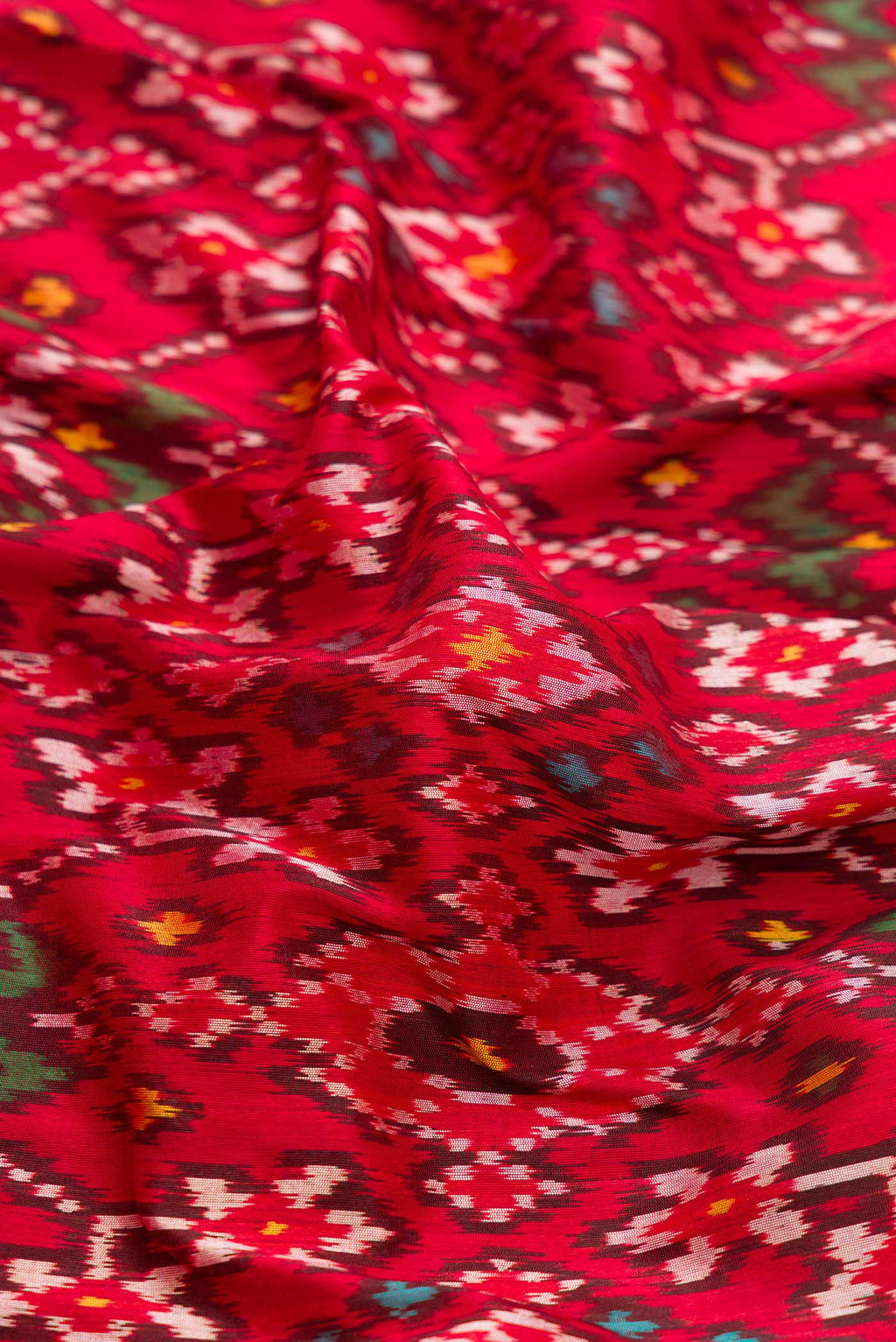 Close up of Pure Silk Pure Zari Red Dual Tone Double Ikat Saree with Ikat Print on the body and Fancy Border displaying folds