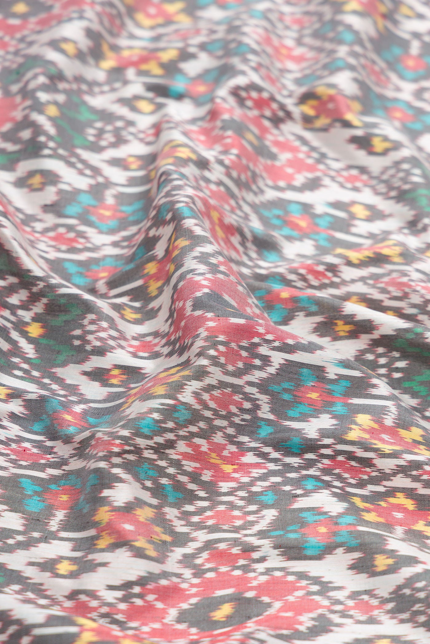 Close up of Grey Dual Tone Double Ikat Saree with Ikat Print on the body and Zari Border.  displaying folds