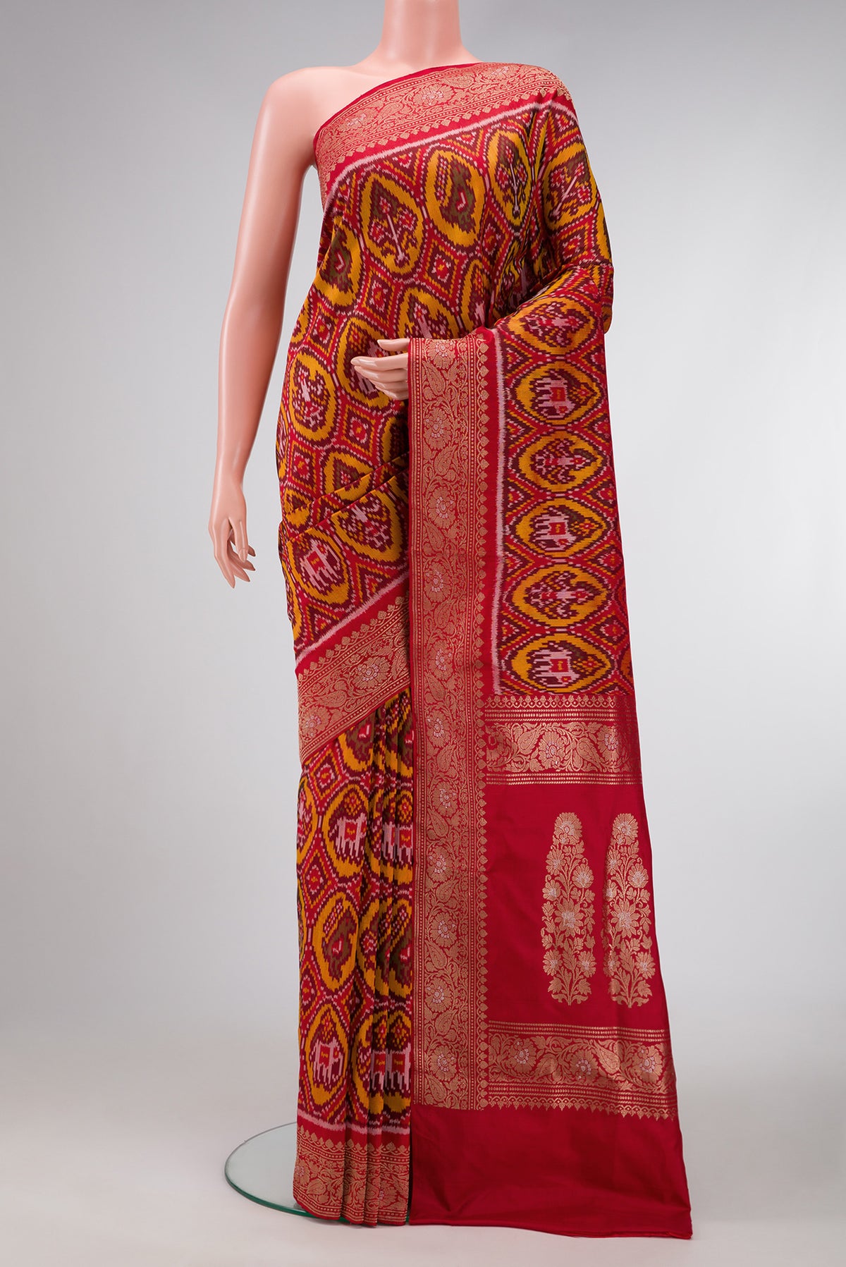 Red Dual Tone Double Ikat Saree with Ikat Print on the body and Zari Border.  displayed on a mannequin