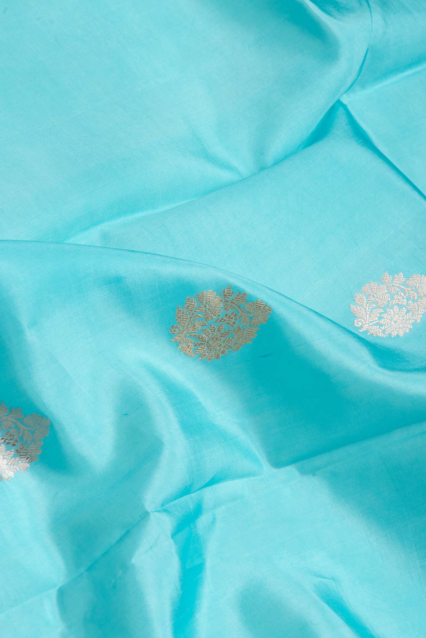 Close up of Sky Blue Dual Tone Banarasi Silk Saree with Zari Butta on the body and Fancy Border.  displaying folds