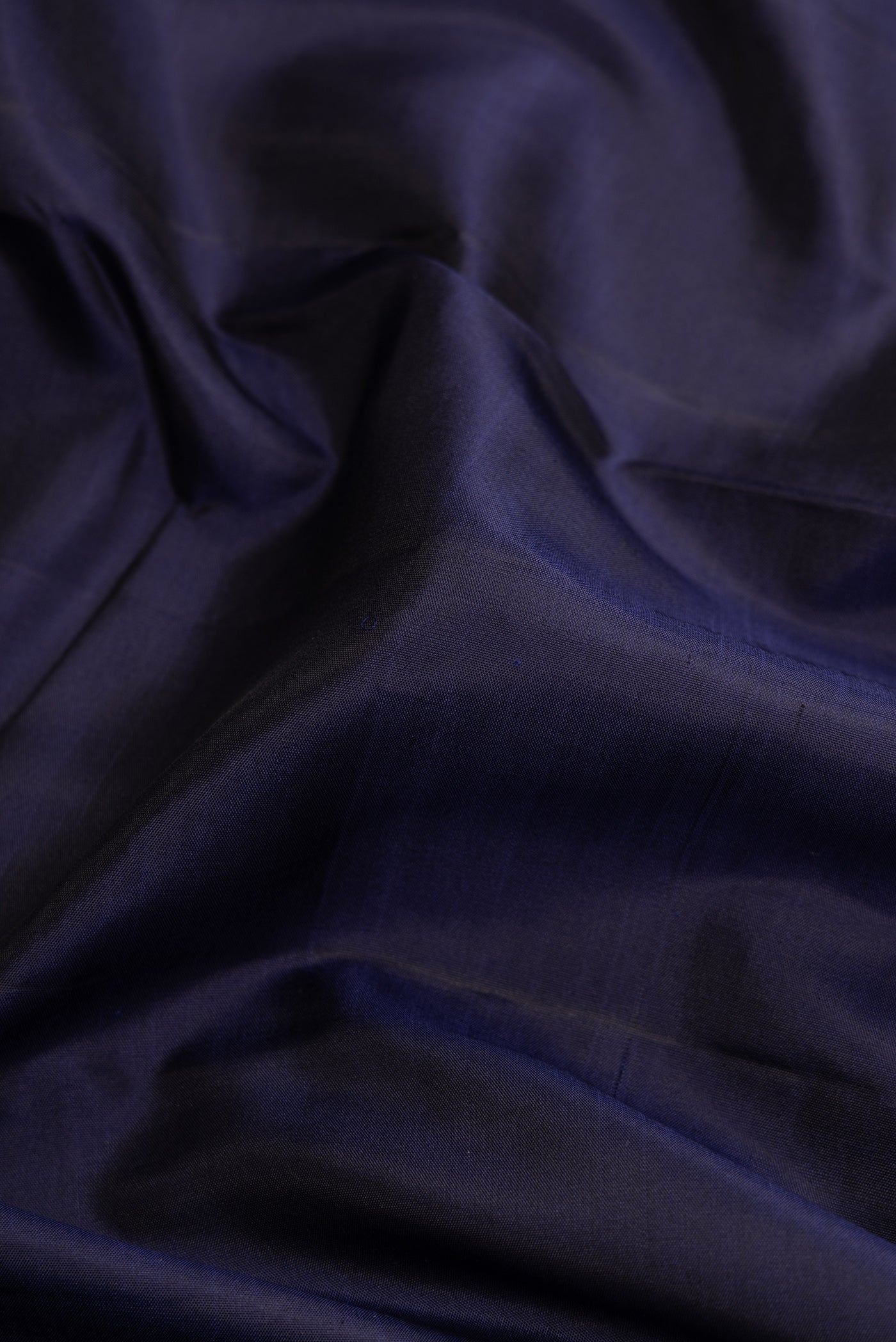 Close up of Pure Silk Pure Zari Navy Blue Dual Tone Kanjivaram Saree with Plain Body and Checks Border.  displaying folds