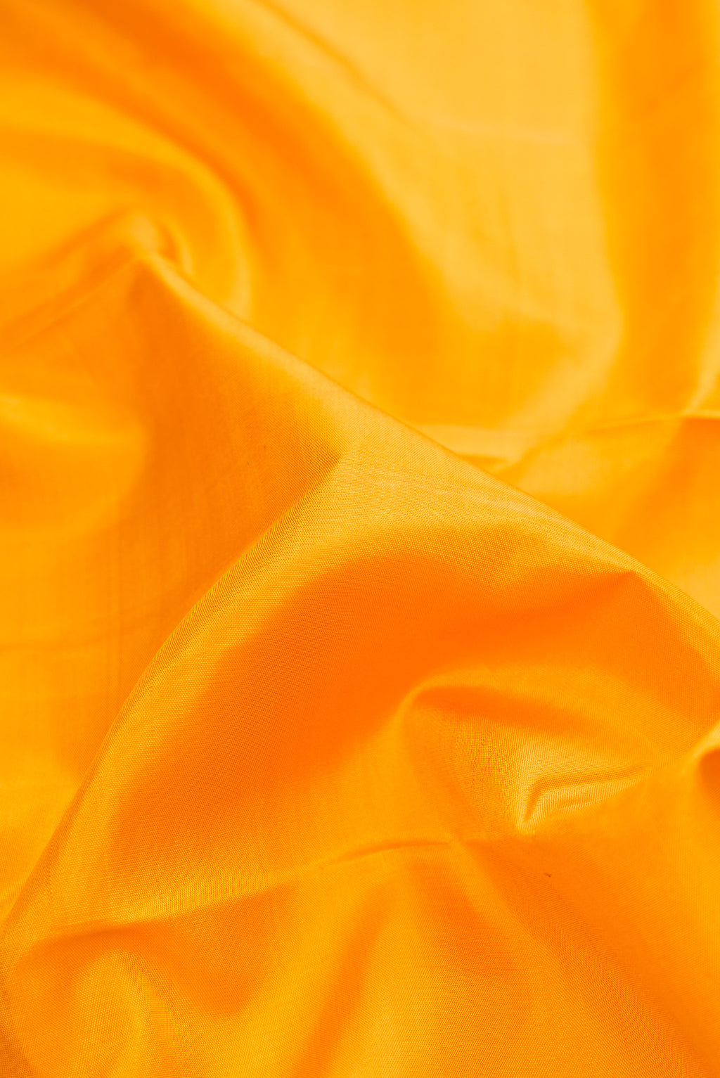 Close up of Pure Silk Pure Zari Yellow Dual Tone Kanjivaram Saree with Plain Body and Checks Border.  displaying folds