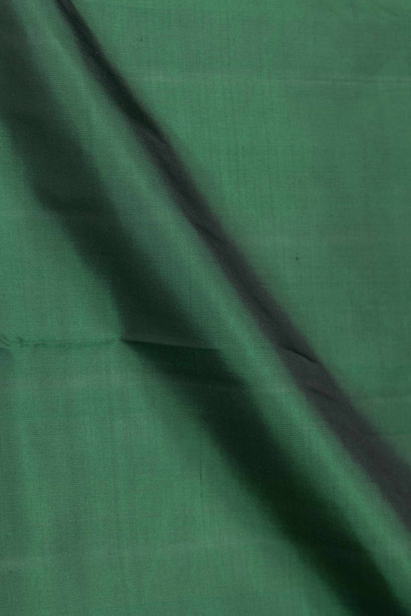 Close up of Green Dual Tone Kanjivaram Saree with Plain Body and Plain Border.  displaying folds