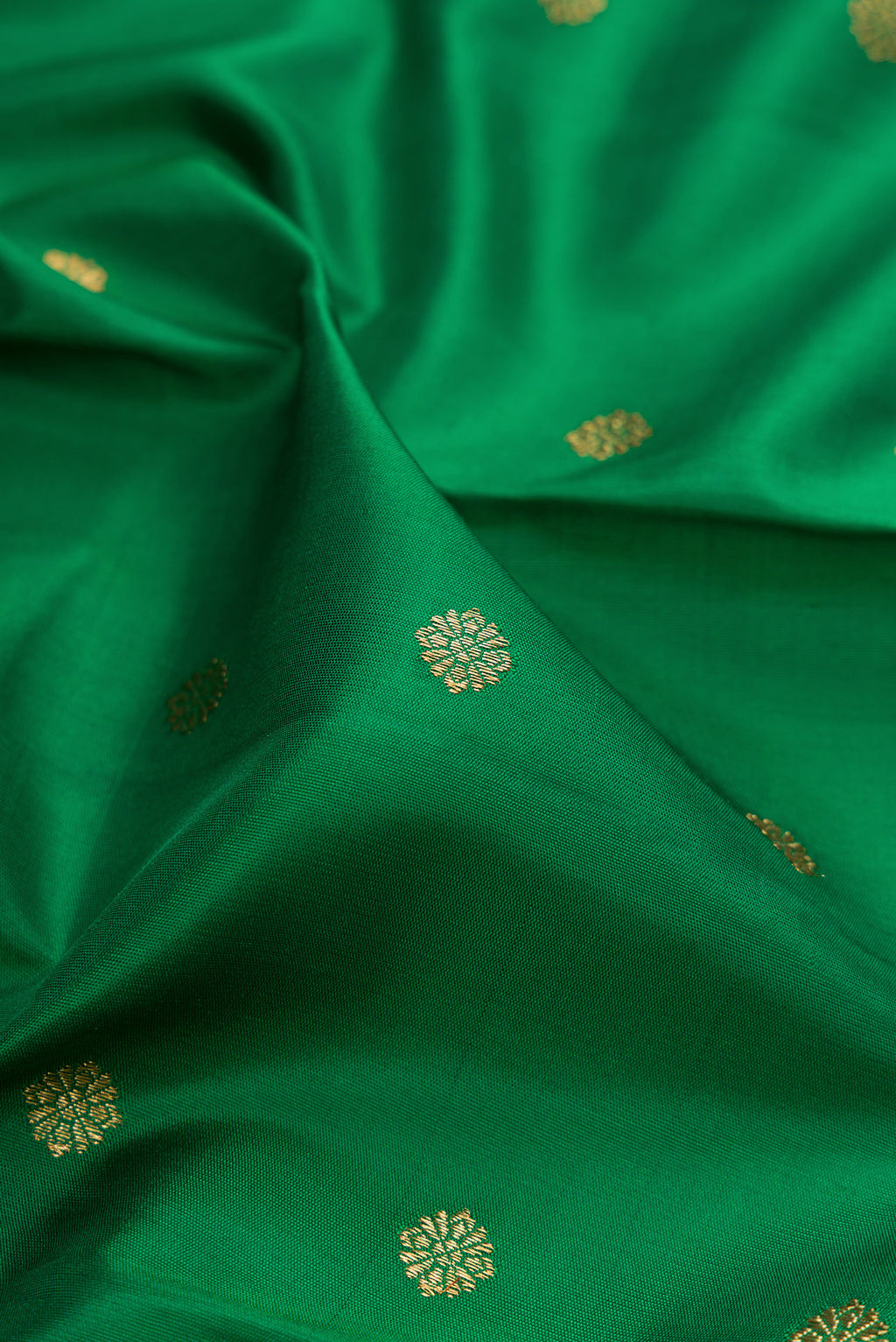 Close up of Pure Silk Pure Zari Green Kanjivaram Saree with Zari Butta on the body and Zari Border.  displaying folds