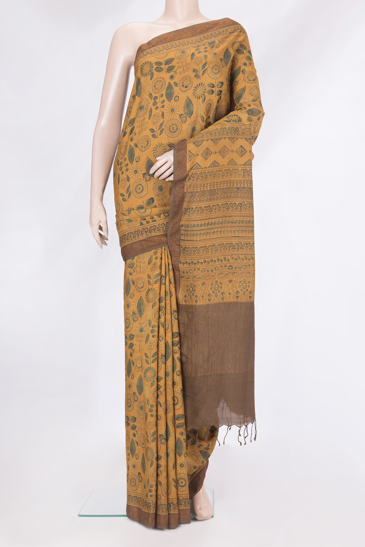 Mustard Tussar Silk Saree with Printed design on the body and Zari Border.  displayed on a mannequin
