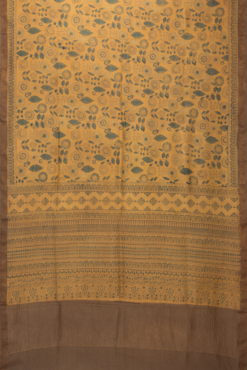 Flat view of Mustard Tussar Silk Saree with Printed design on the body and Zari Border. 