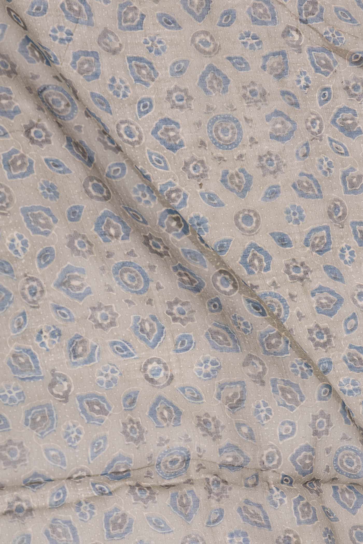 Close up of Grey Dual Tone Chanderi Silk Saree with Printed design on the body and Zari Border displaying folds