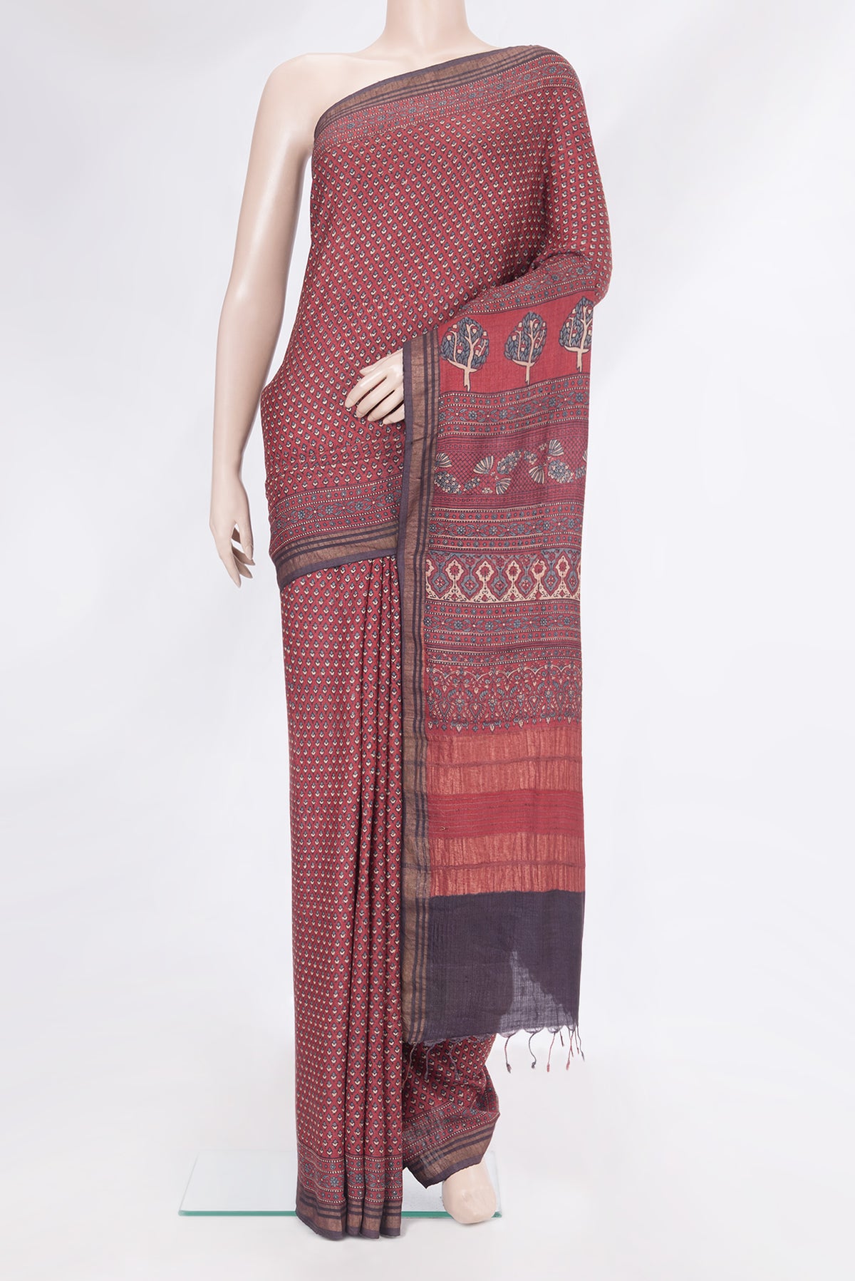 Maroon Jute Silk Saree with Ajrakh Print on the body and Zari Border.  displayed on a mannequin