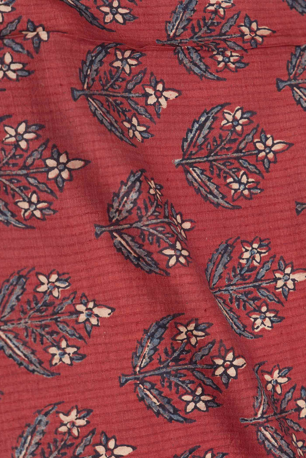Close up of Maroon Dual Tone Tussar Silk Saree with Printed design on the body and Zari Border displaying folds