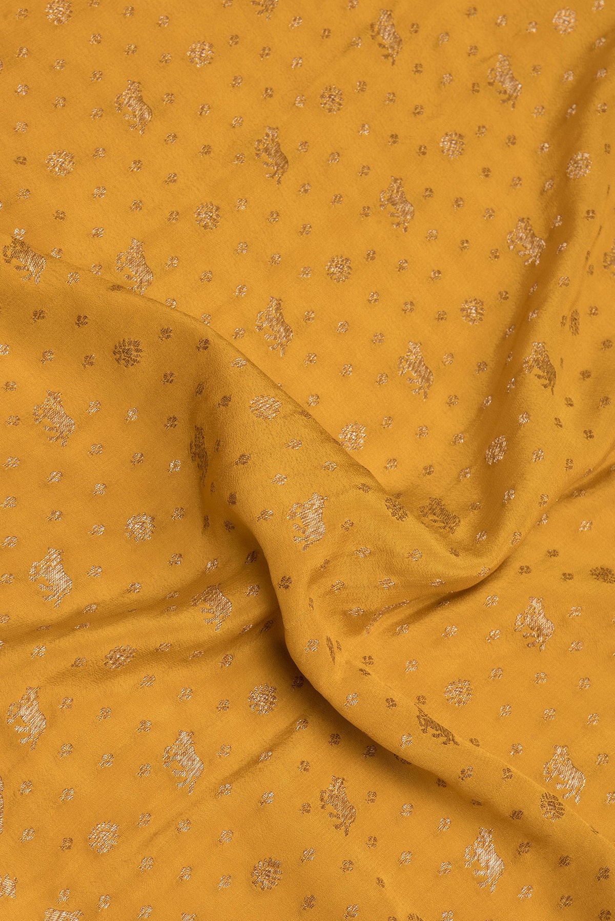 Close up of Mustard Banarasi Georgette Saree with Zari Butta on the body and Zari Border.  displaying folds