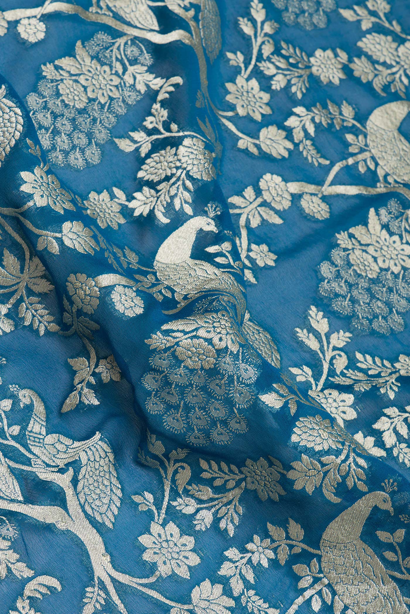 Close up of Peacock Blue Banarasi Georgette Saree with Zari Brocade on the body and Zari Border.  displaying folds