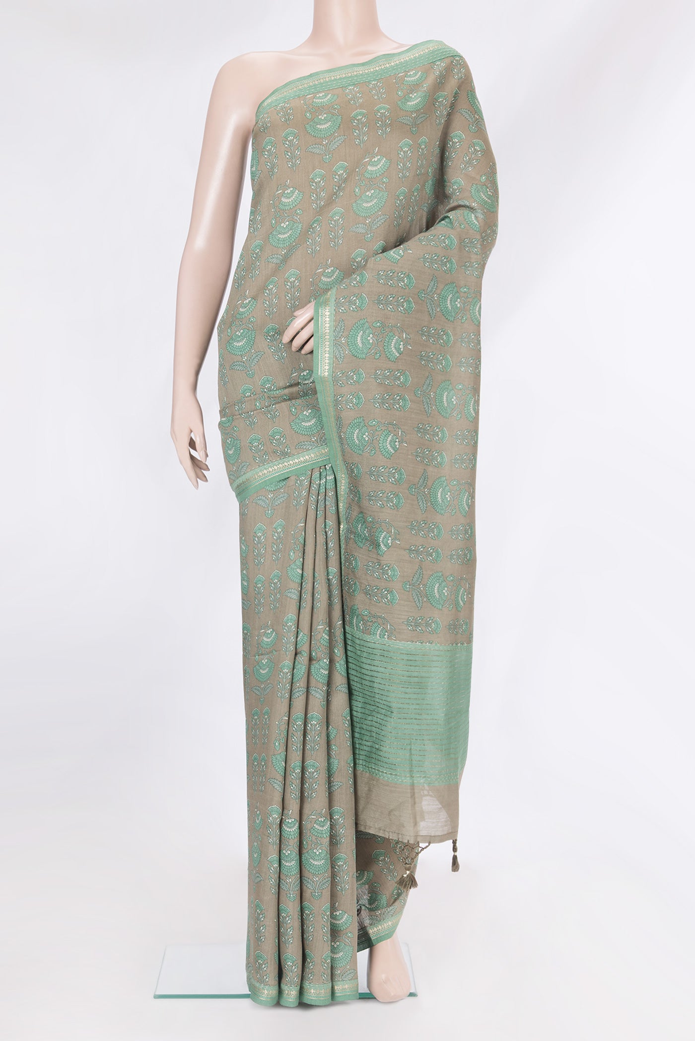 Green Tussar Silk Saree with Printed design on the body and Zari Border.  displayed on a mannequin