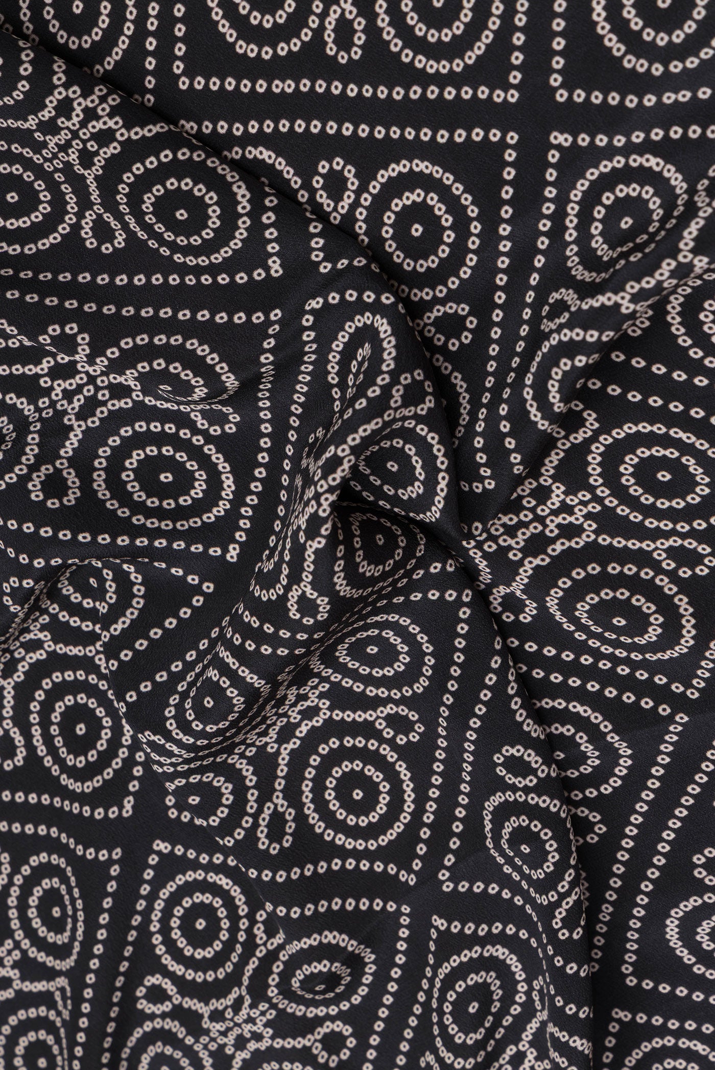 Close up of Black Crepe Saree with Bandhani Print on the body and Printed Border.  displaying folds