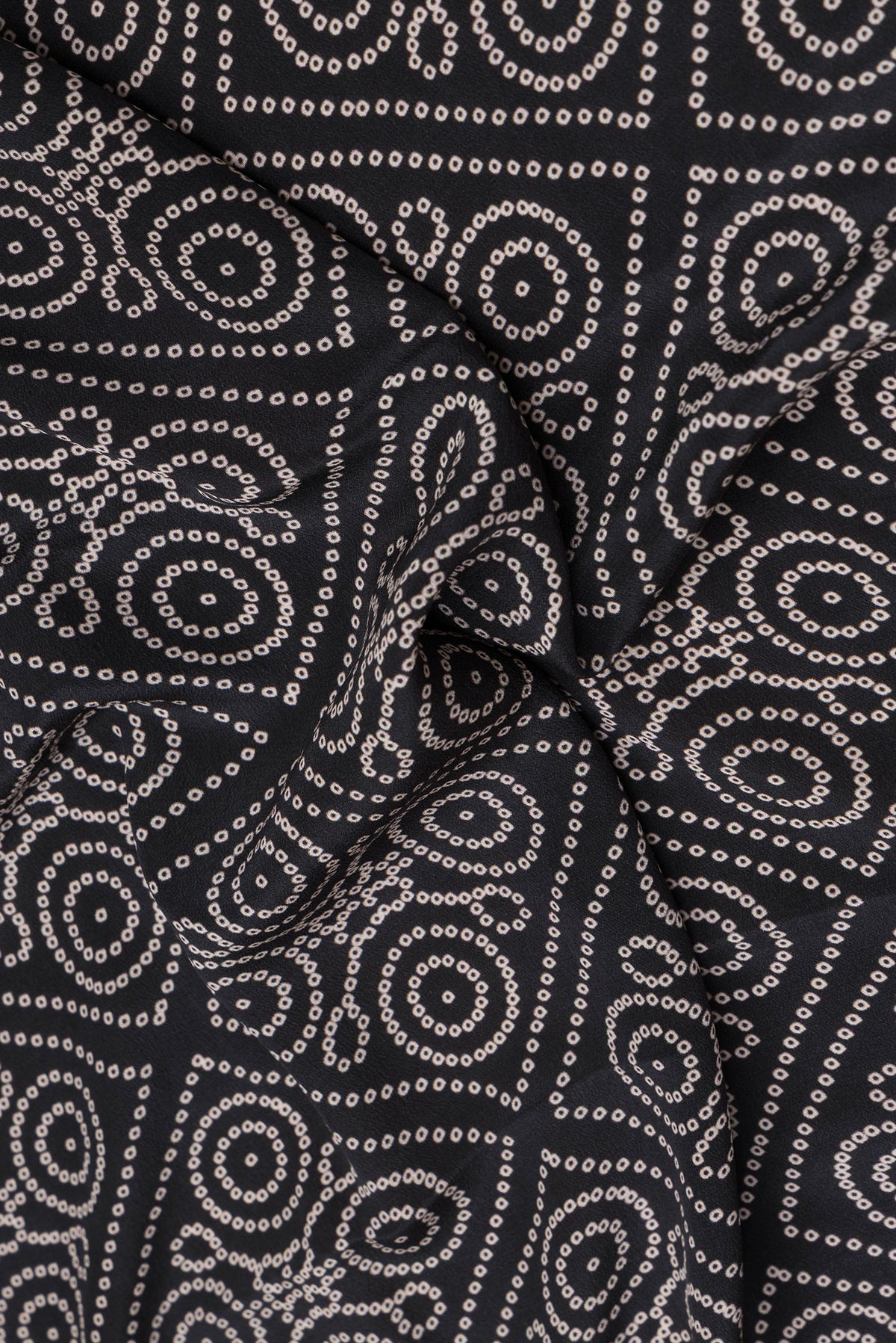 Close up of Black Crepe Saree with Bandhani Print on the body and Printed Border.  displaying folds