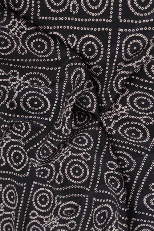 Close up of Black Crepe Saree with Bandhani Print on the body and Printed Border.  displaying folds