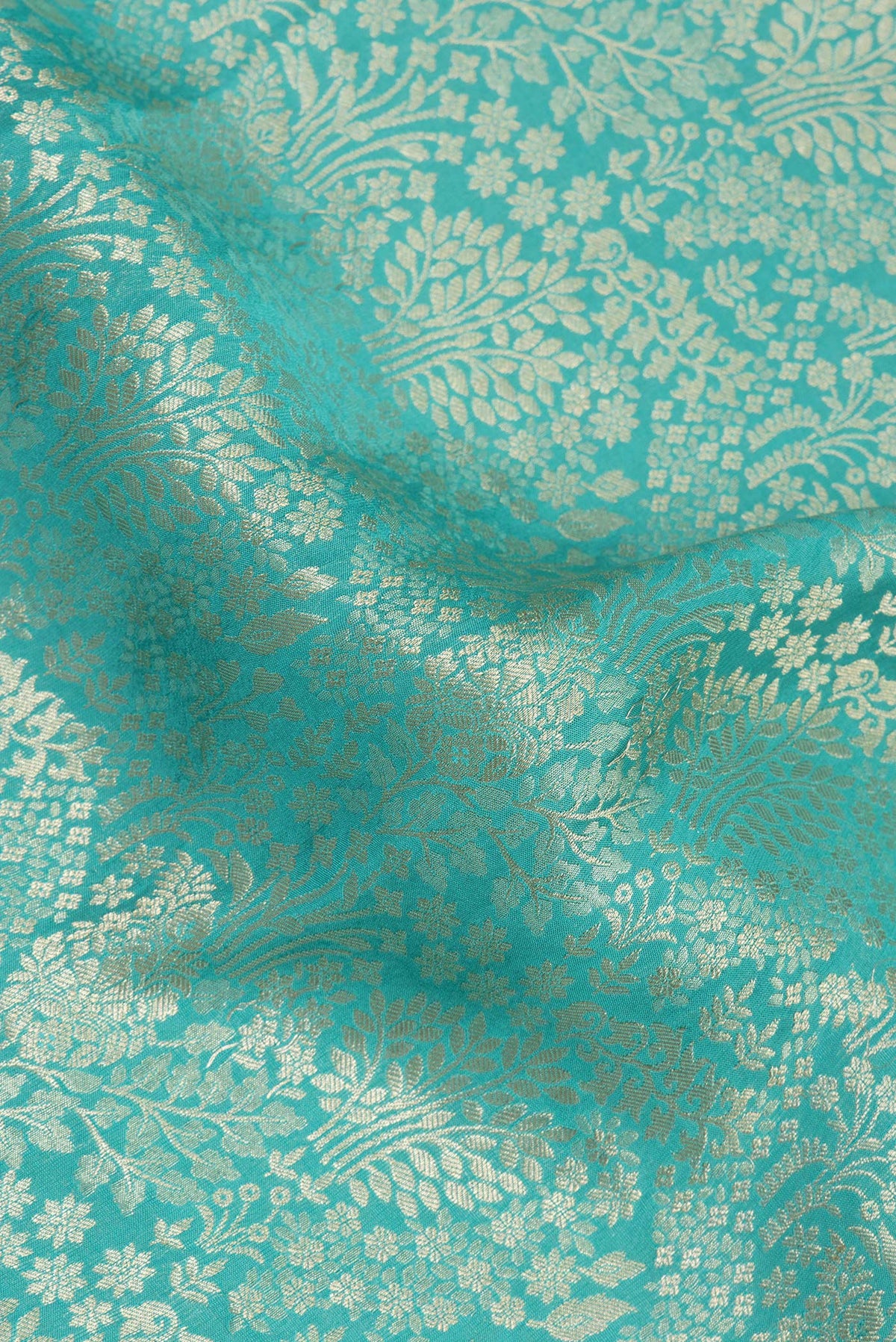 Close up of Turquoise Dual Tone Banarasi Georgette Saree with Zari Brocade on the body and Zari Border.  displaying folds