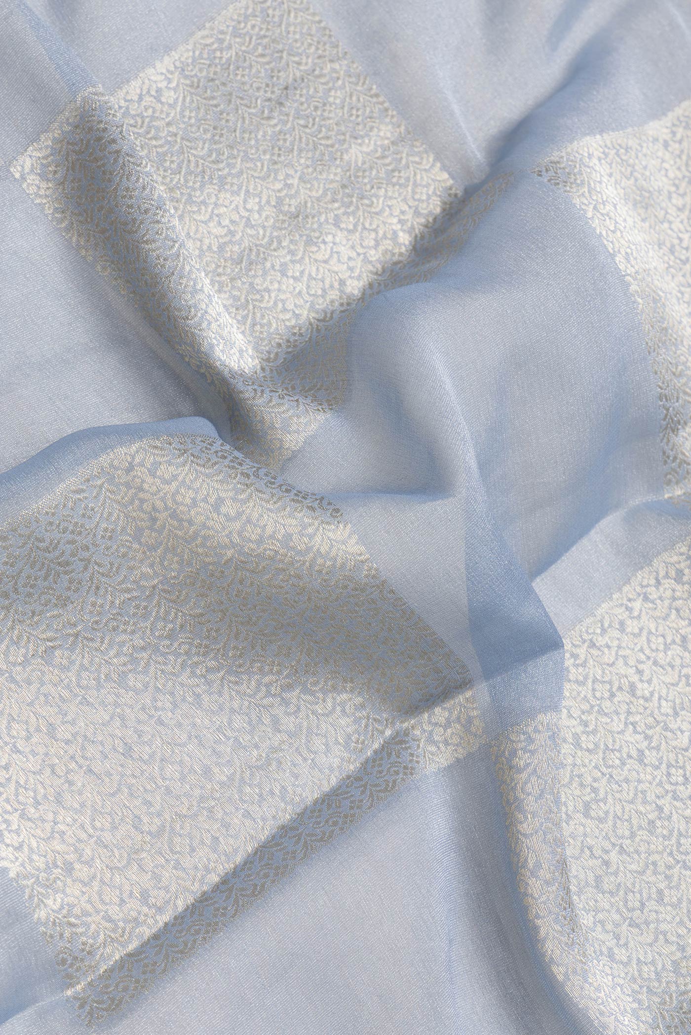 Close up of Grey Dual Tone Mysore Georgette Saree with Zari Brocade on the body and Zari Border.  displaying folds