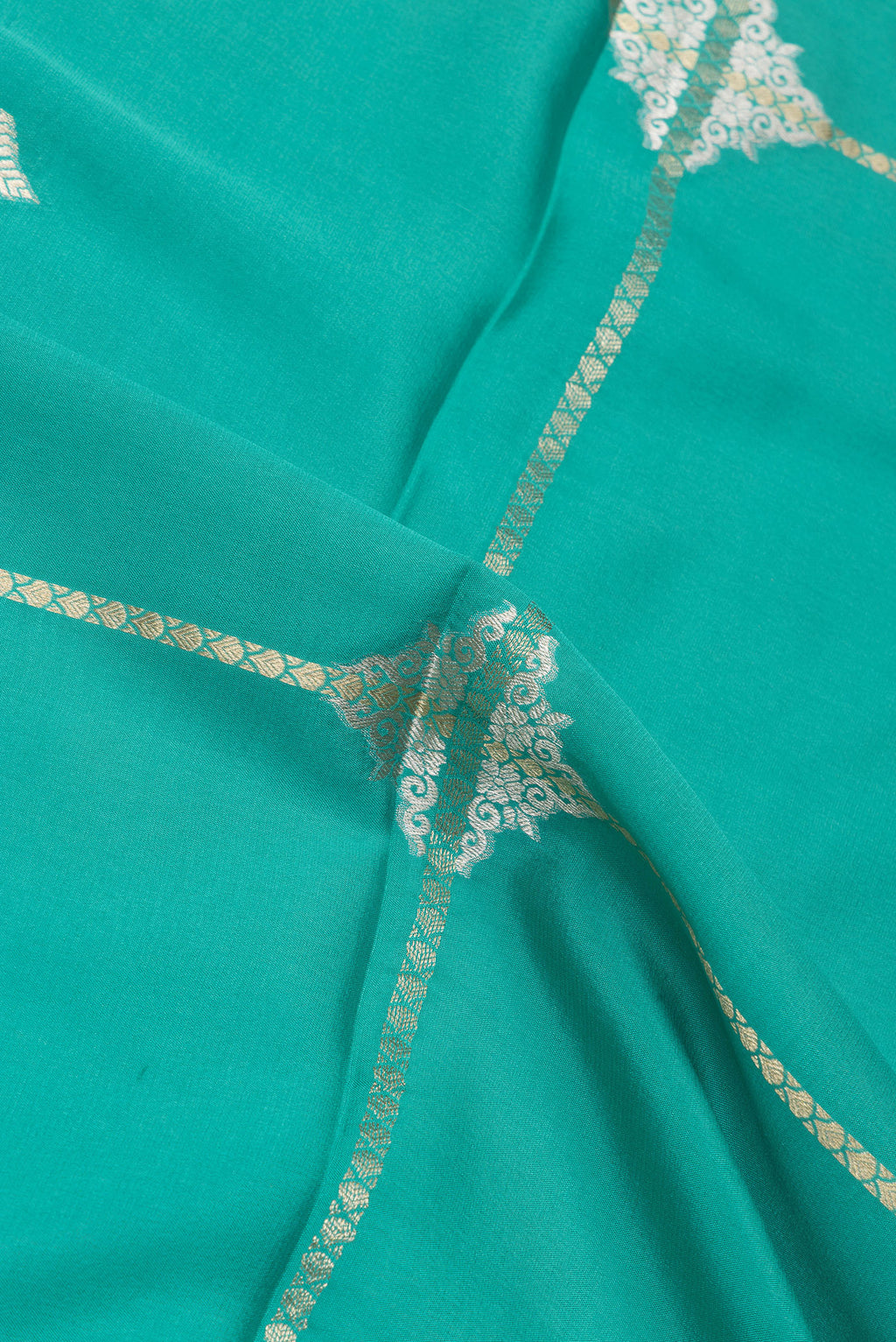 Close up of Teal Mysore Silk Saree with Zari Butta on the body and Zari Border.  displaying folds