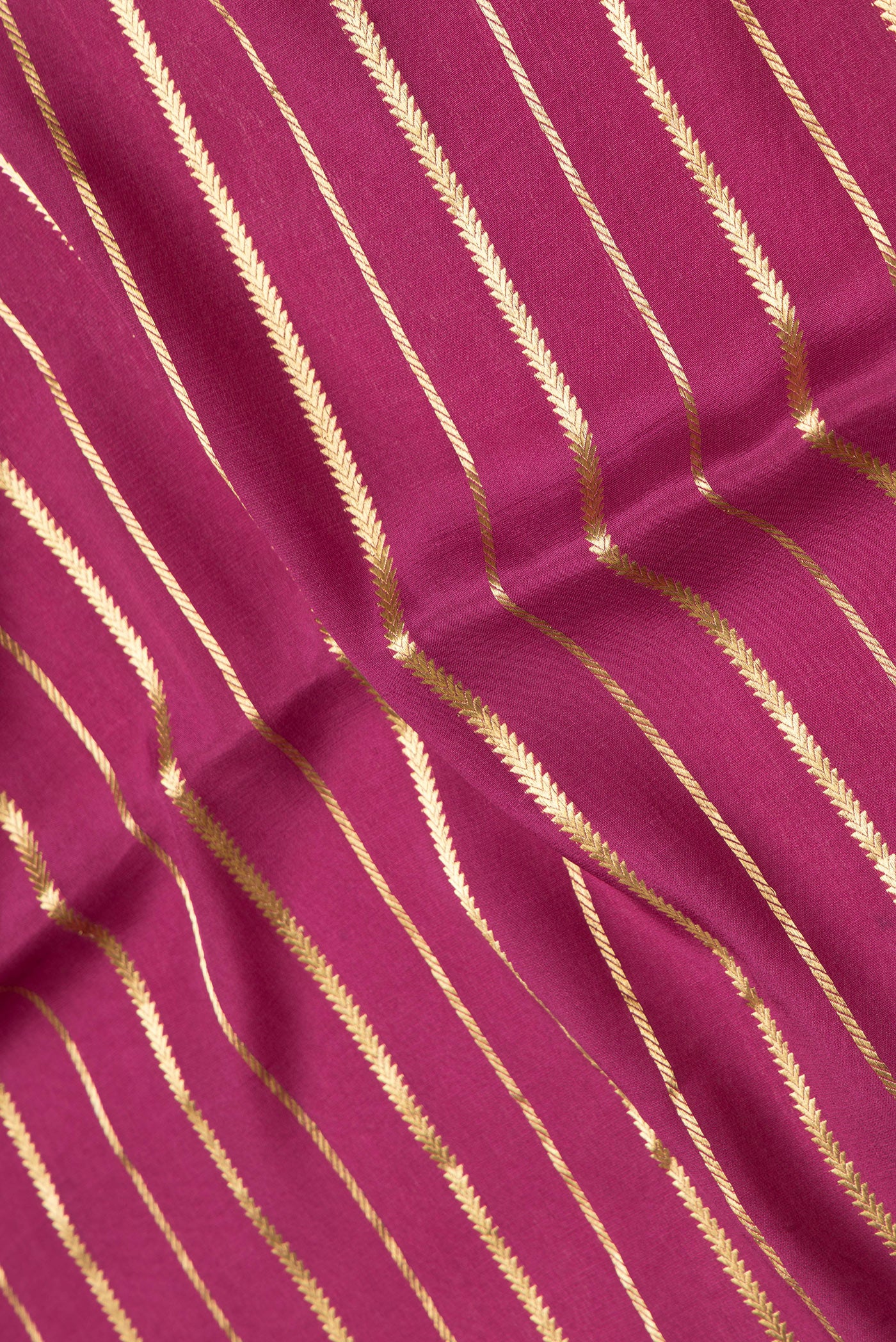 Close up of Magenta Dual Tone Mysore Silk Saree with Stripes on the body and Zari Border.  displaying folds