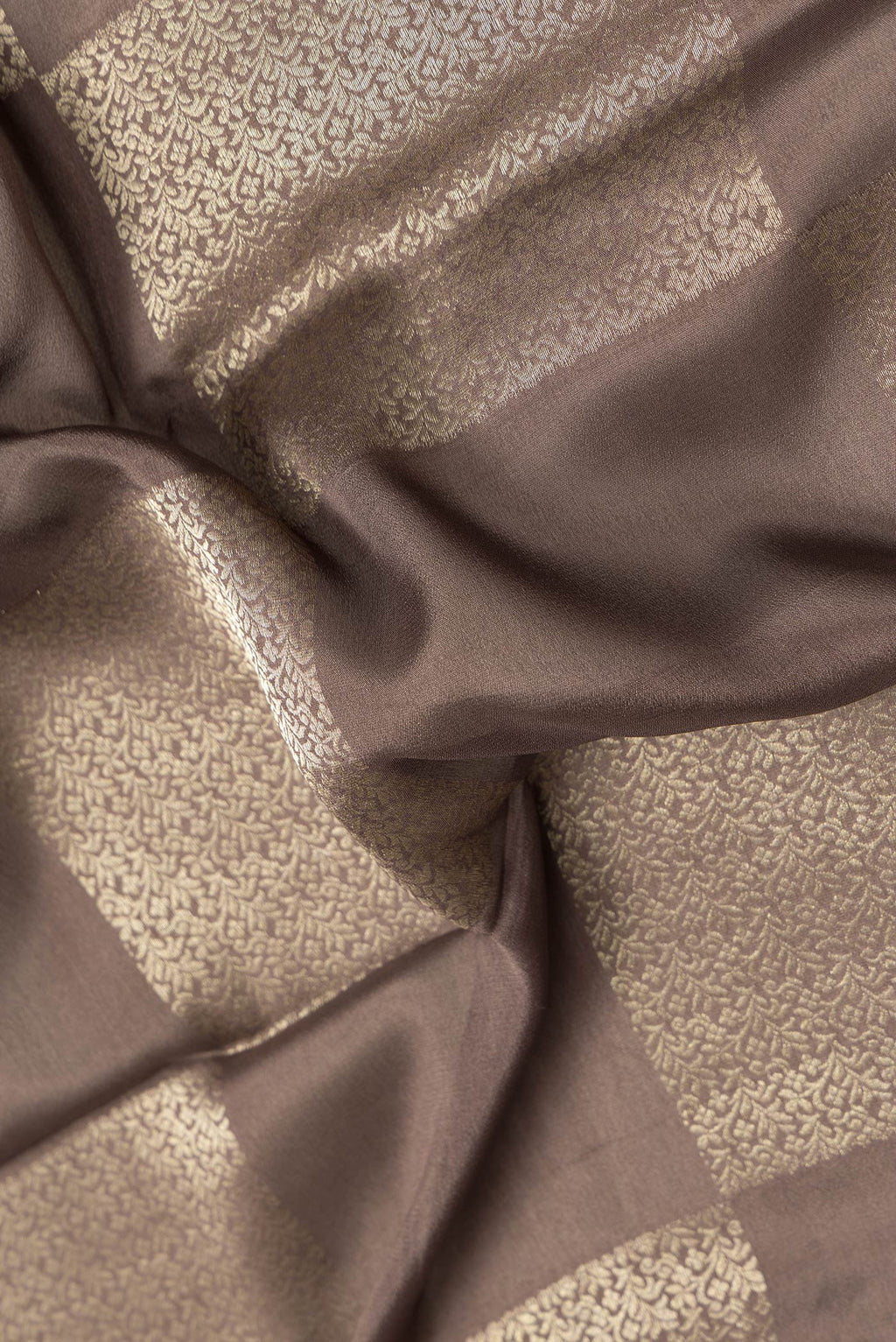 Close up of Brown Dual Tone Mysore Georgette Saree with Zari Brocade on the body and Zari Border.  displaying folds
