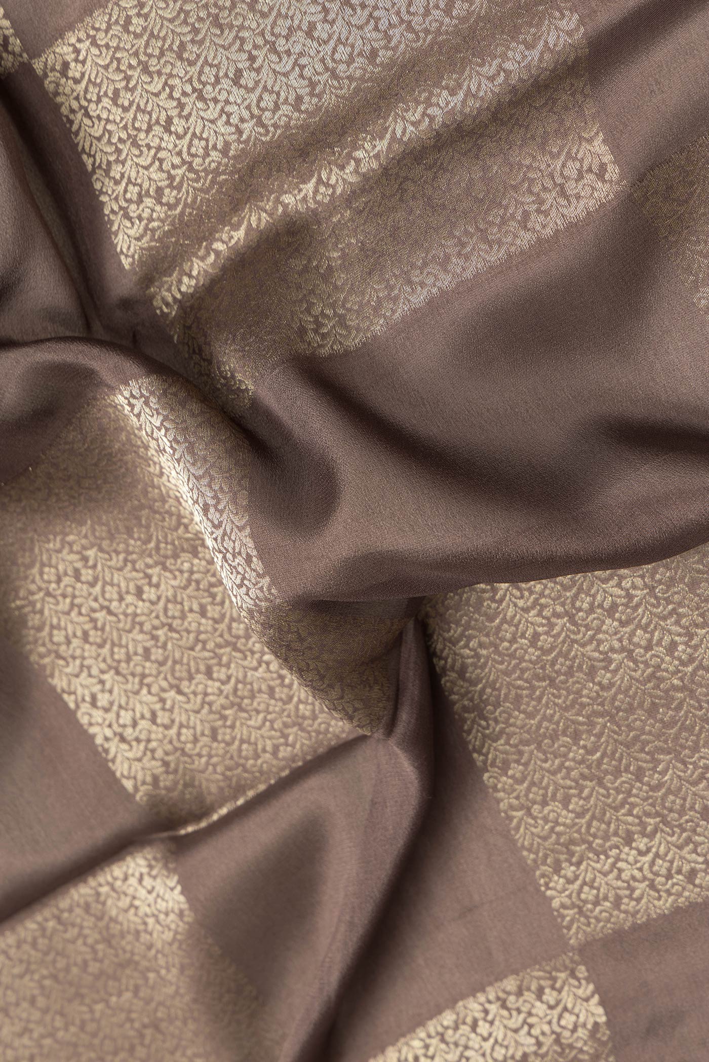 Close up of Brown Dual Tone Mysore Georgette Saree with Zari Brocade on the body and Zari Border.  displaying folds
