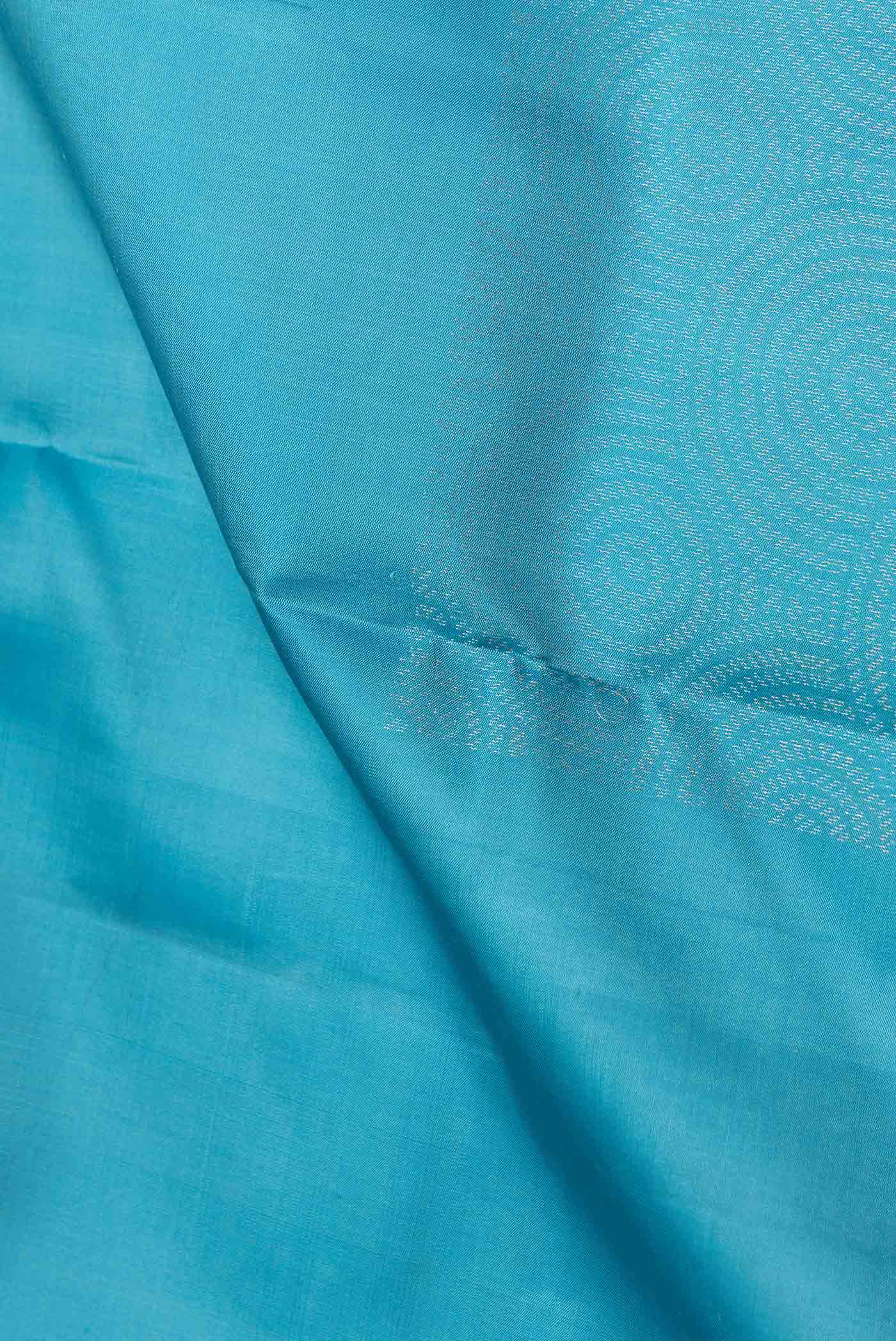 Close up of Sky Blue Dual Tone Soft Silk Saree with Zari Butta on the body and Without Border.  displaying folds