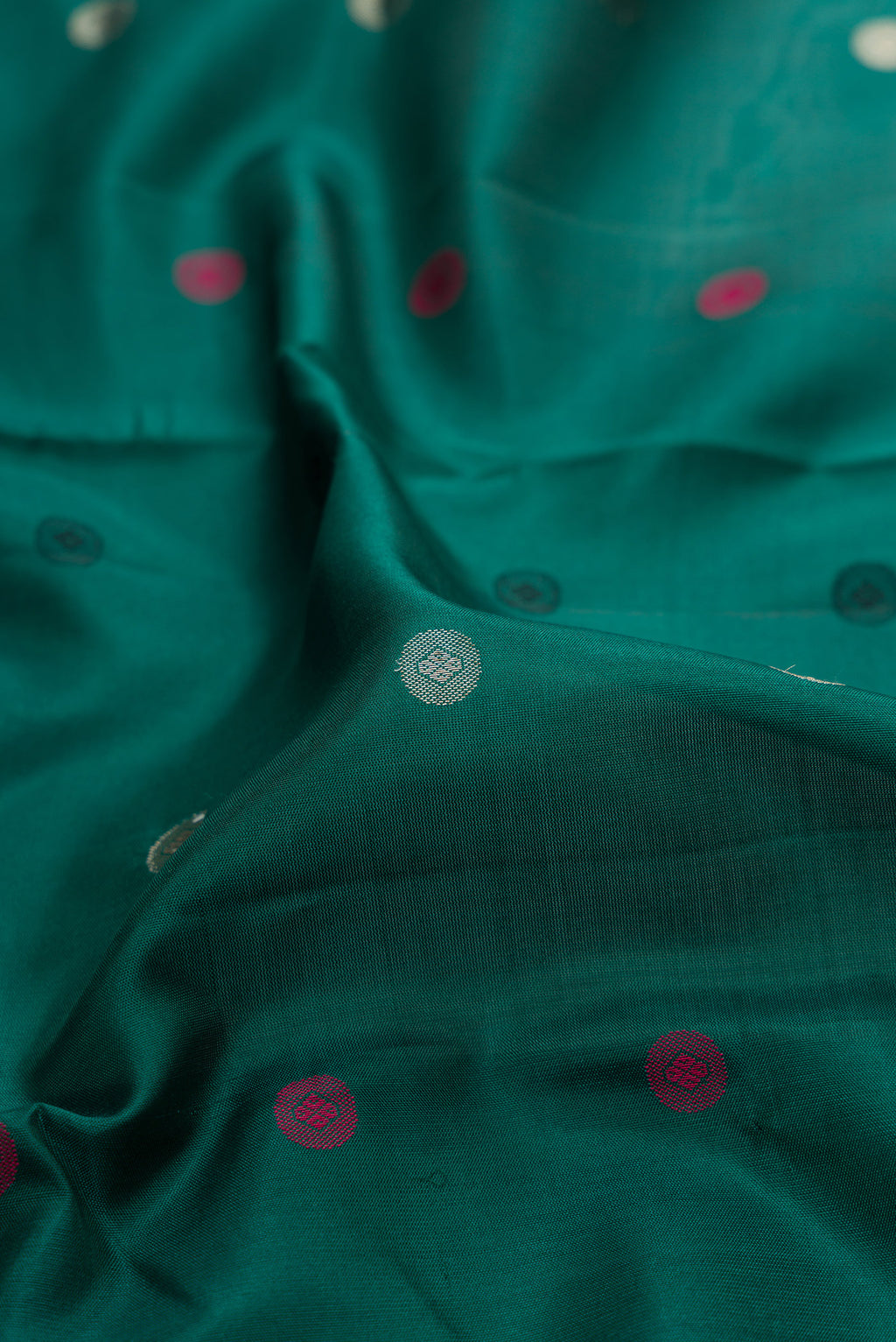 Close up of Bottle Green Kanchipuram Silk Saree with Zari And Thread Butta on the body and Zari And Thread Border.  displaying folds