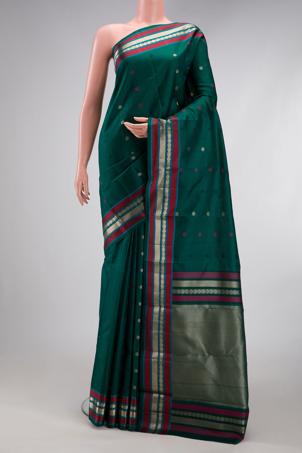 Bottle Green Kanchipuram Silk Saree with Zari And Thread Butta on the body and Zari And Thread Border.  displayed on a mannequin