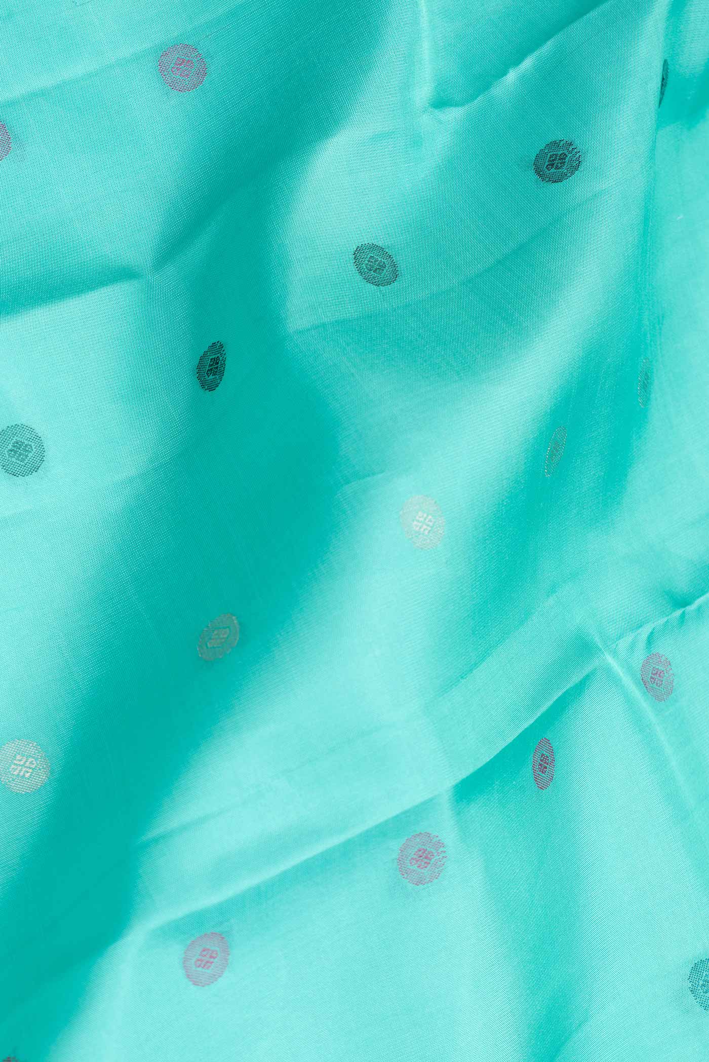 Close up of Sea Green Dual Tone Kanchipuram Silk Saree with Zari And Thread Butta on the body and Zari And Thread Border.  displaying folds