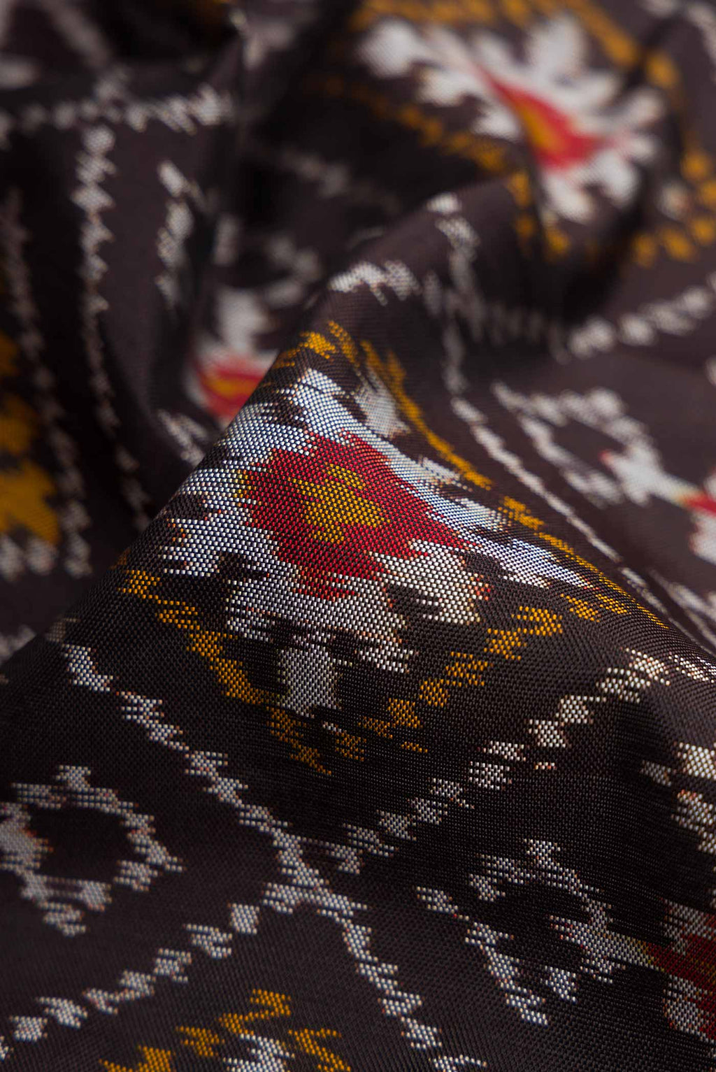 Close up of Black Pochampally Silk Saree with Pure Ikat on the body and Plain Border displaying folds