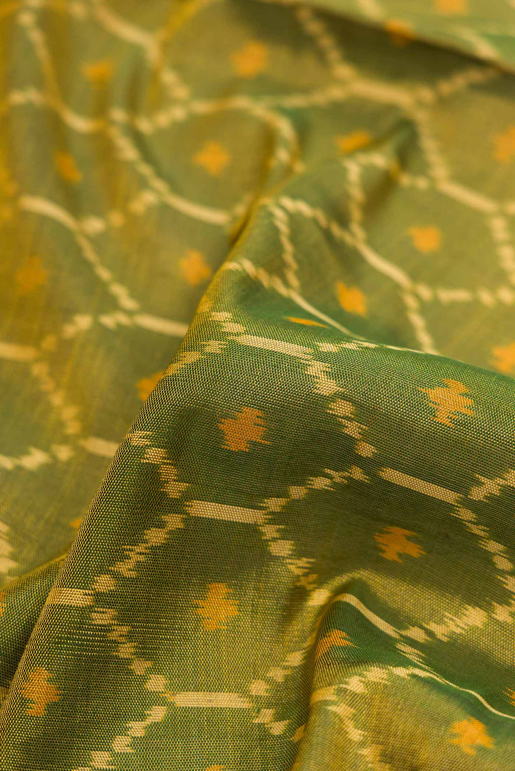 Close up of Mehandi Green Dual Tone Rajkot Patola Silk Saree with Ikat Print on the body and Ikat Border displaying folds