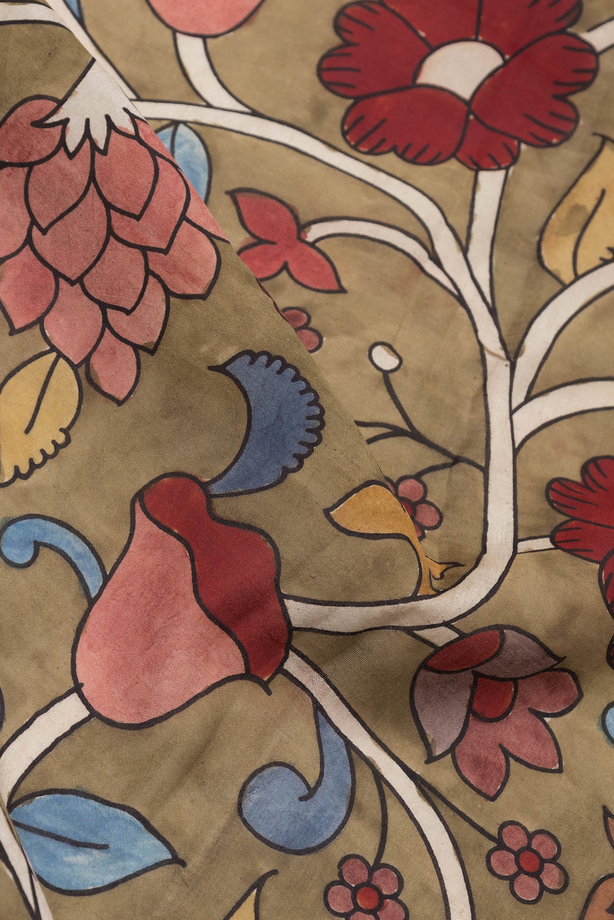 Close up of Brown Tussar Silk Saree with kalamkari Print on the body and Zari Border.  displaying folds