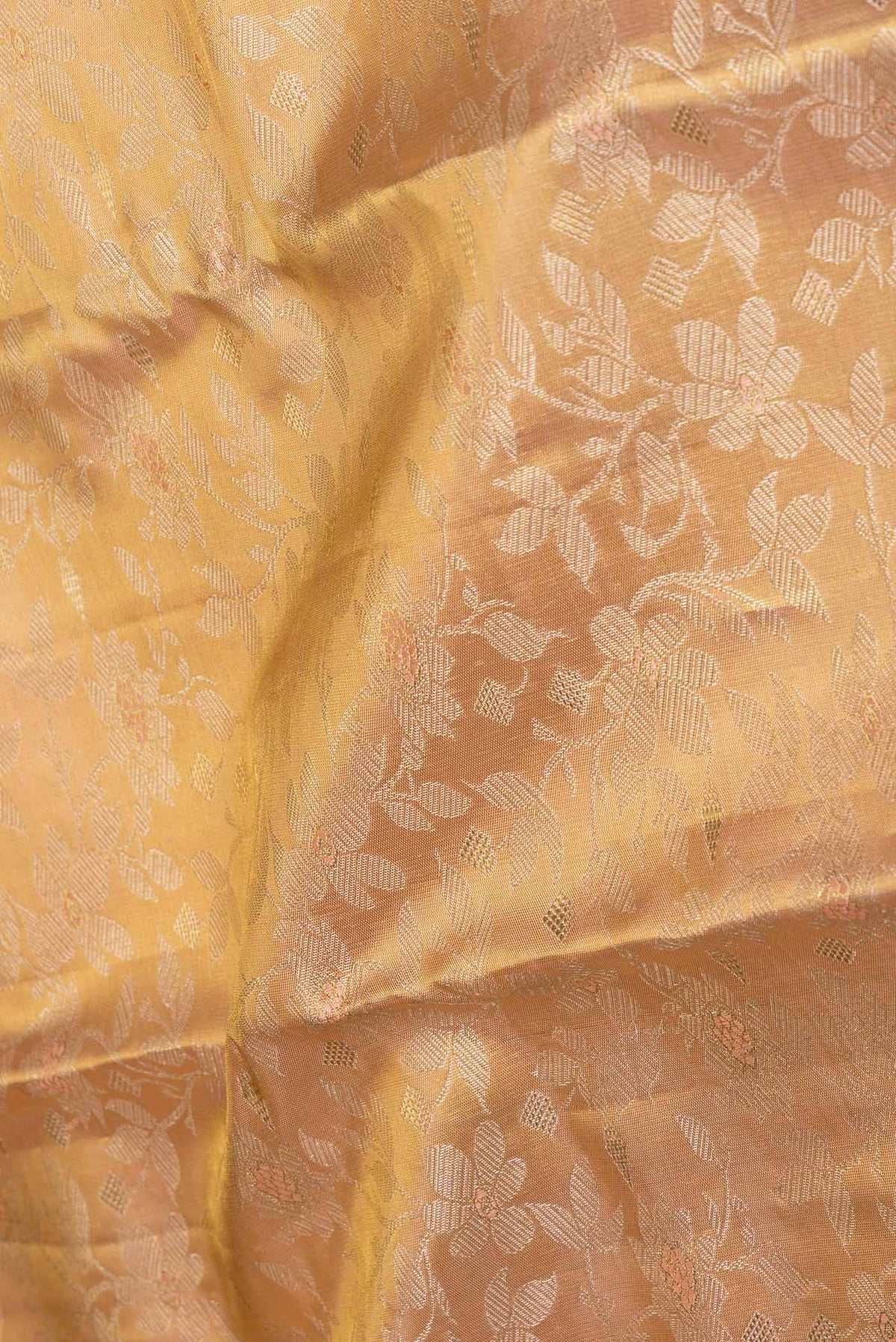 Close up of Golden Peach Dual Tone Kanchipuram Saree with Zari Brocade on the body and Zari Border displaying folds