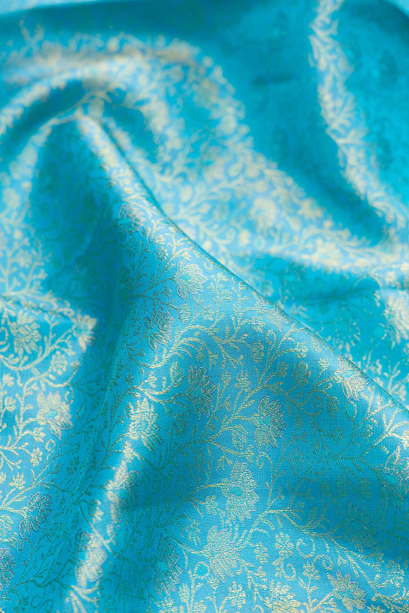 Close up of Sky Blue Dual Tone Kanchipuram Silk Saree with Zari Brocade on the body and Zari Border.  displaying folds