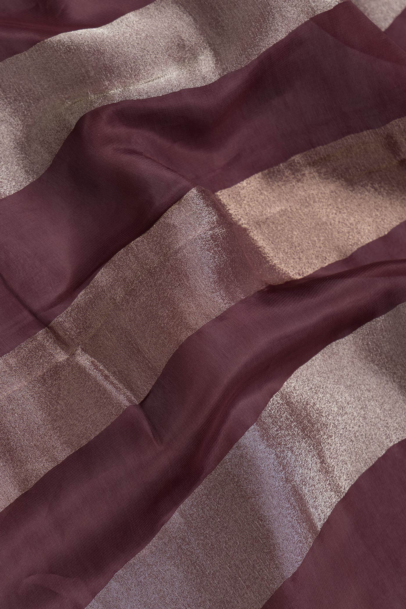 Close up of Maroon Dual Tone Banarasi Georgette Saree with Stripes on the body and Embroidery Border.  displaying folds