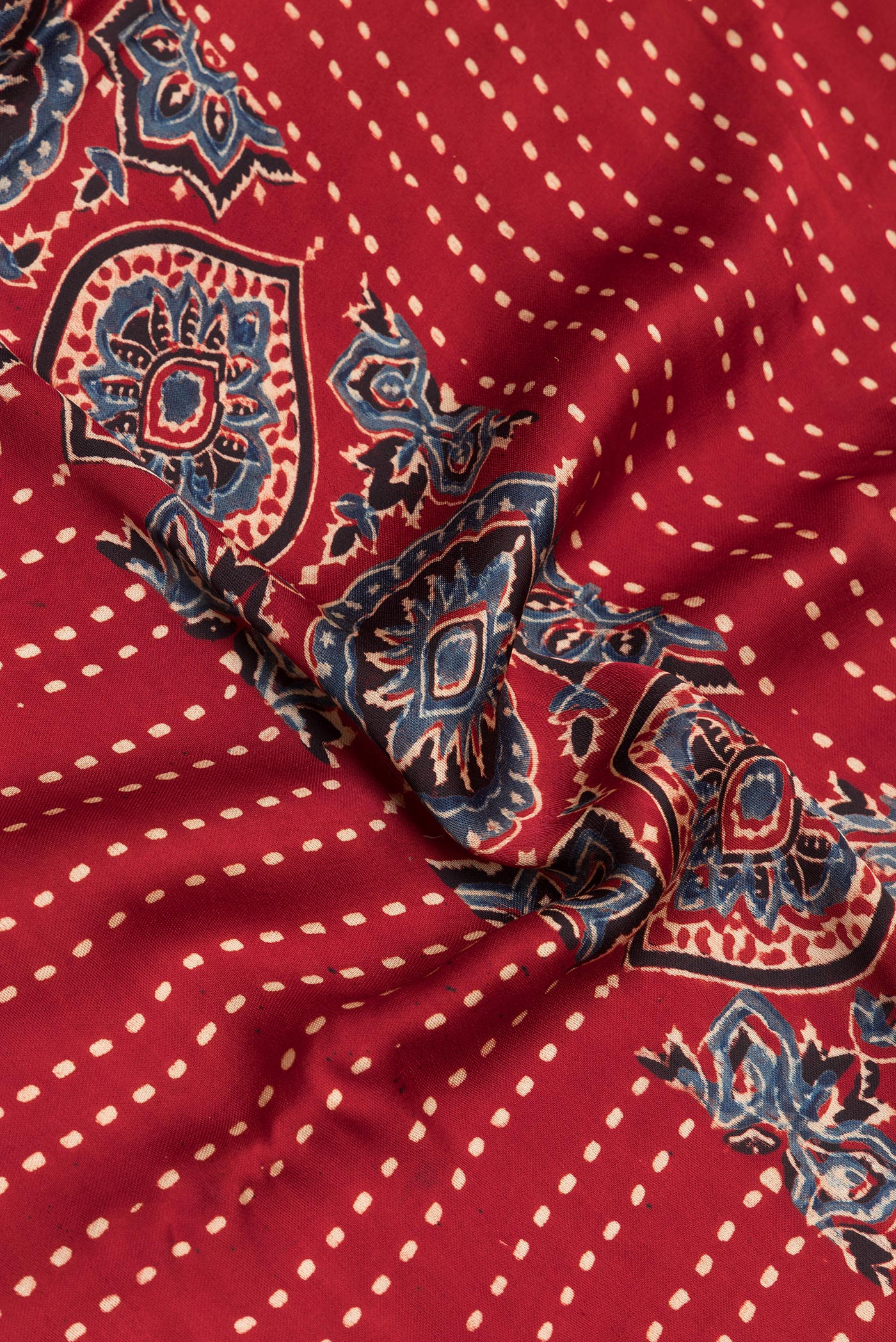 Close up of Maroon Satin Crepe Saree with Printed design on the body and Printed Border.  displaying folds