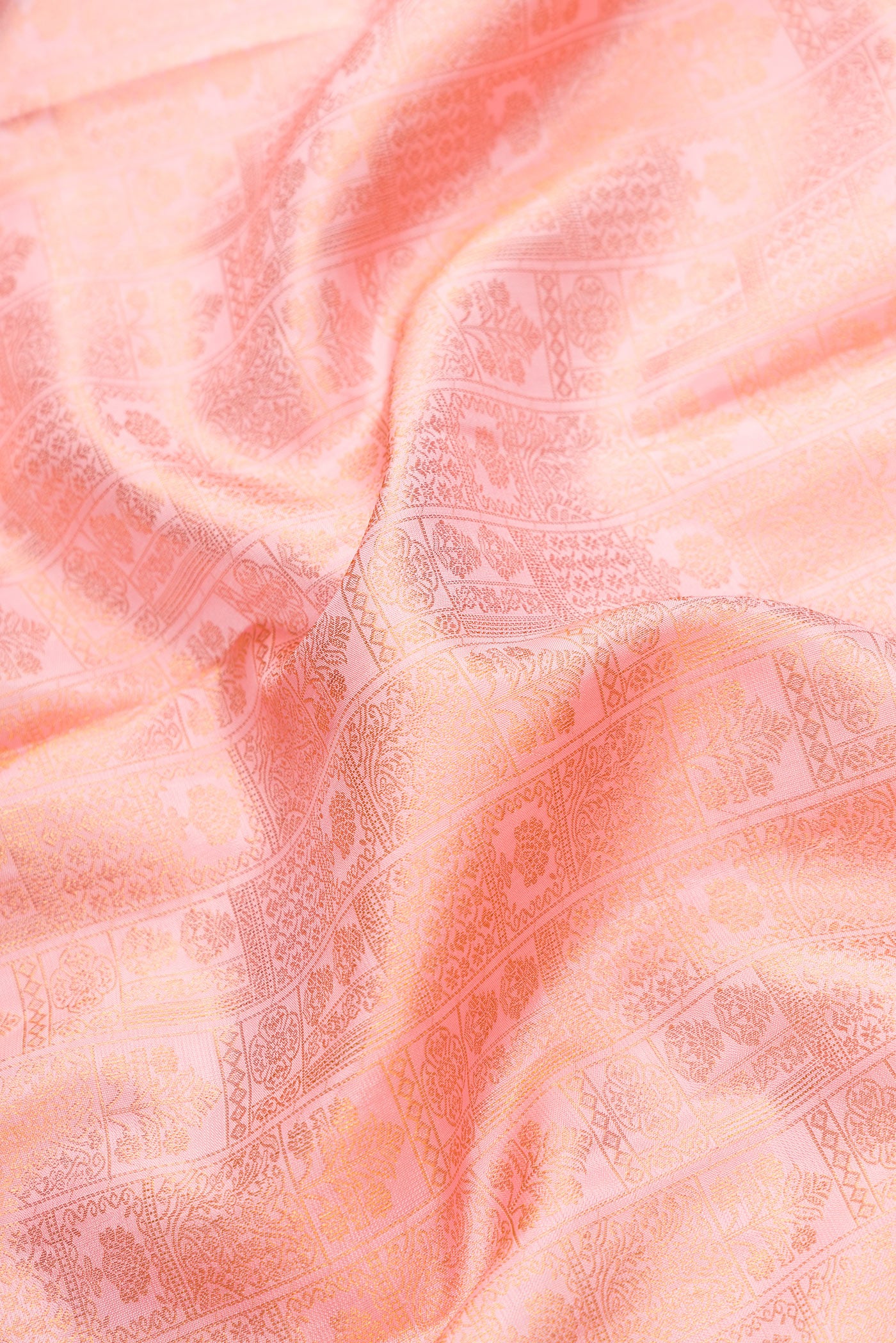 Close up of Rose Gold Dual Tone Kanchipuram Silk Saree with Zari Brocade on the body and Zari Border.  displaying folds