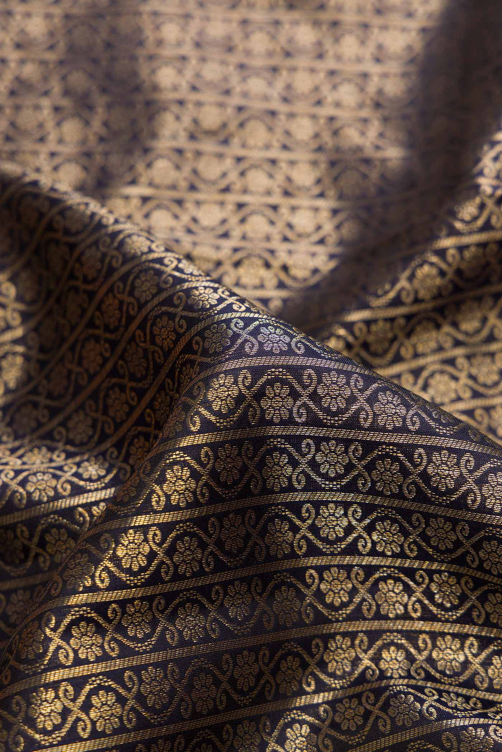 Close up of Black Dual Tone Kanchipuram Silk Saree with Zari Brocade on the body and Zari Border.  displaying folds