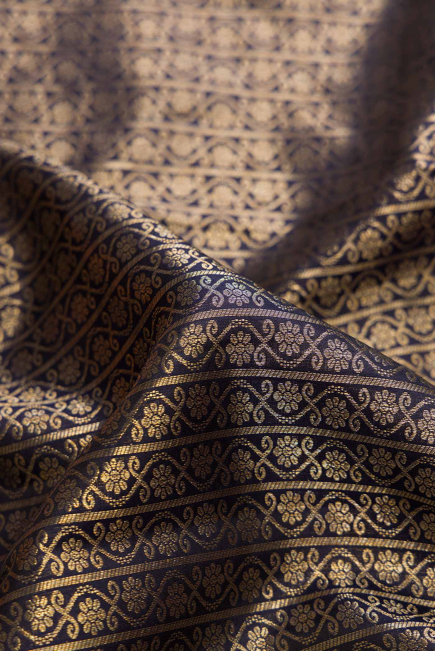 Close up of Black Dual Tone Kanchipuram Silk Saree with Zari Brocade on the body and Zari Border.  displaying folds
