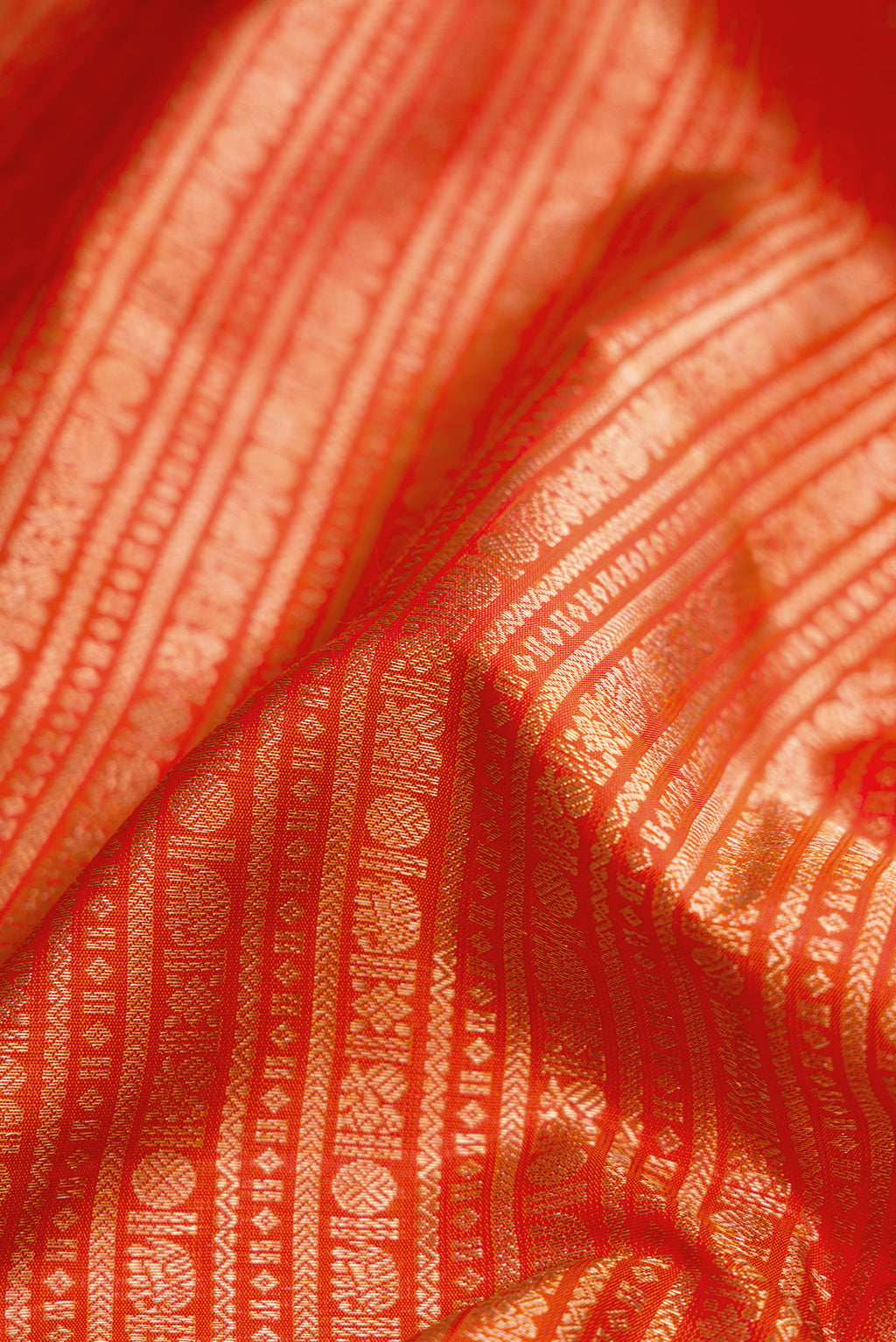 Close up of Orange Kanjivaram Silk Saree with Zari Brocade on the body and Zari Border.  displaying folds