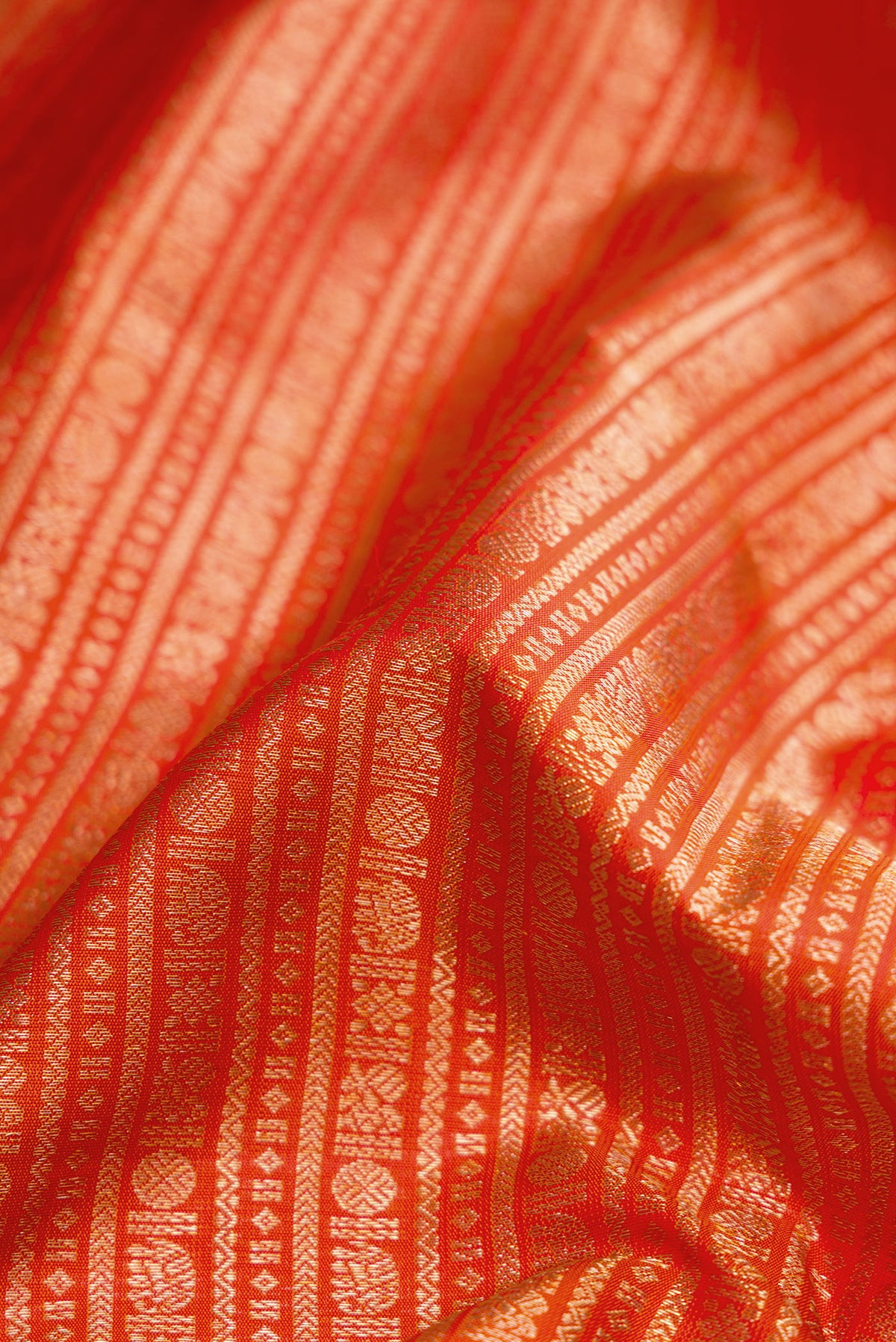 Close up of Orange Kanjivaram Silk Saree with Zari Brocade on the body and Zari Border.  displaying folds