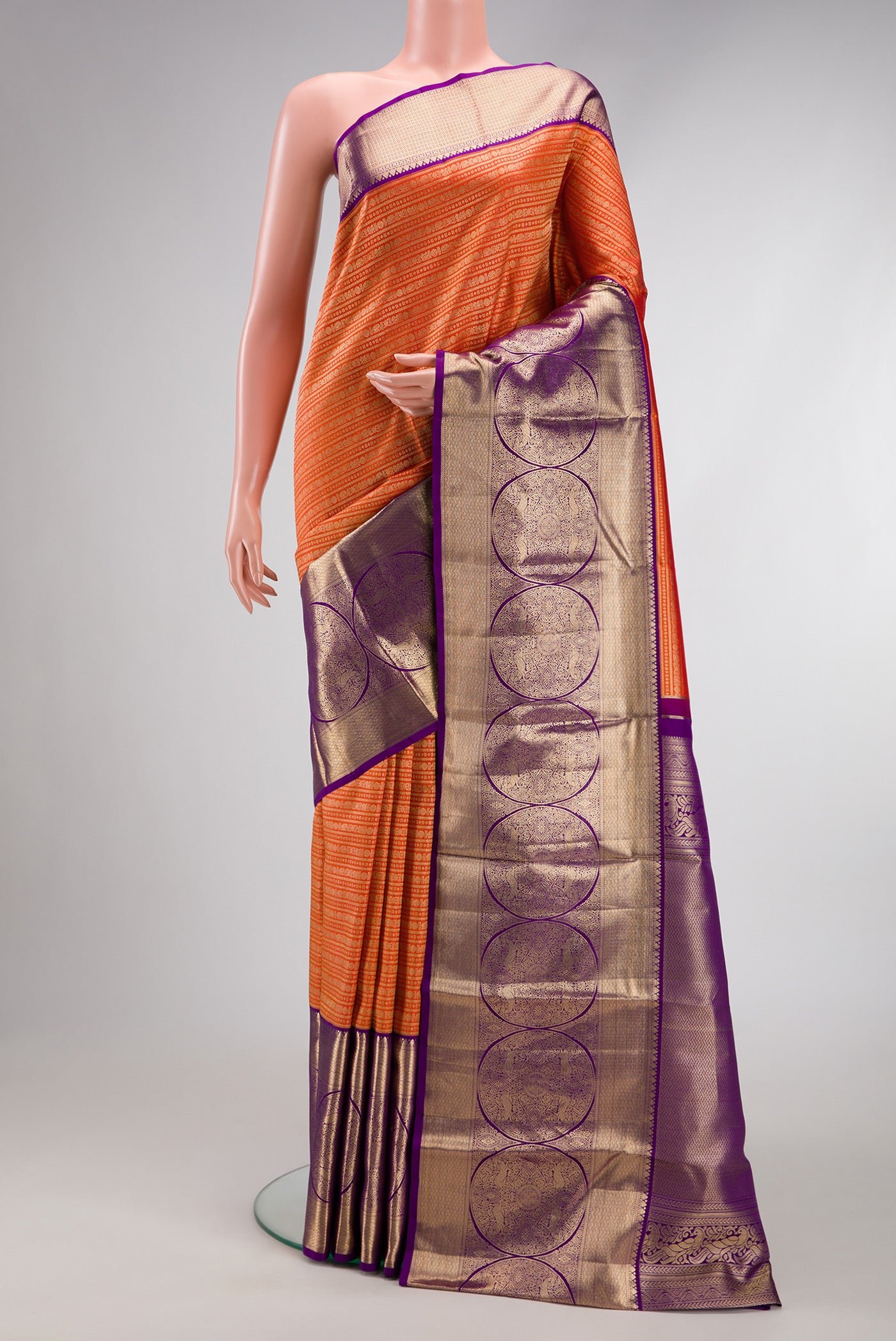 Orange Kanjivaram Silk Saree with Zari Brocade on the body and Zari Border.  displayed on a mannequin
