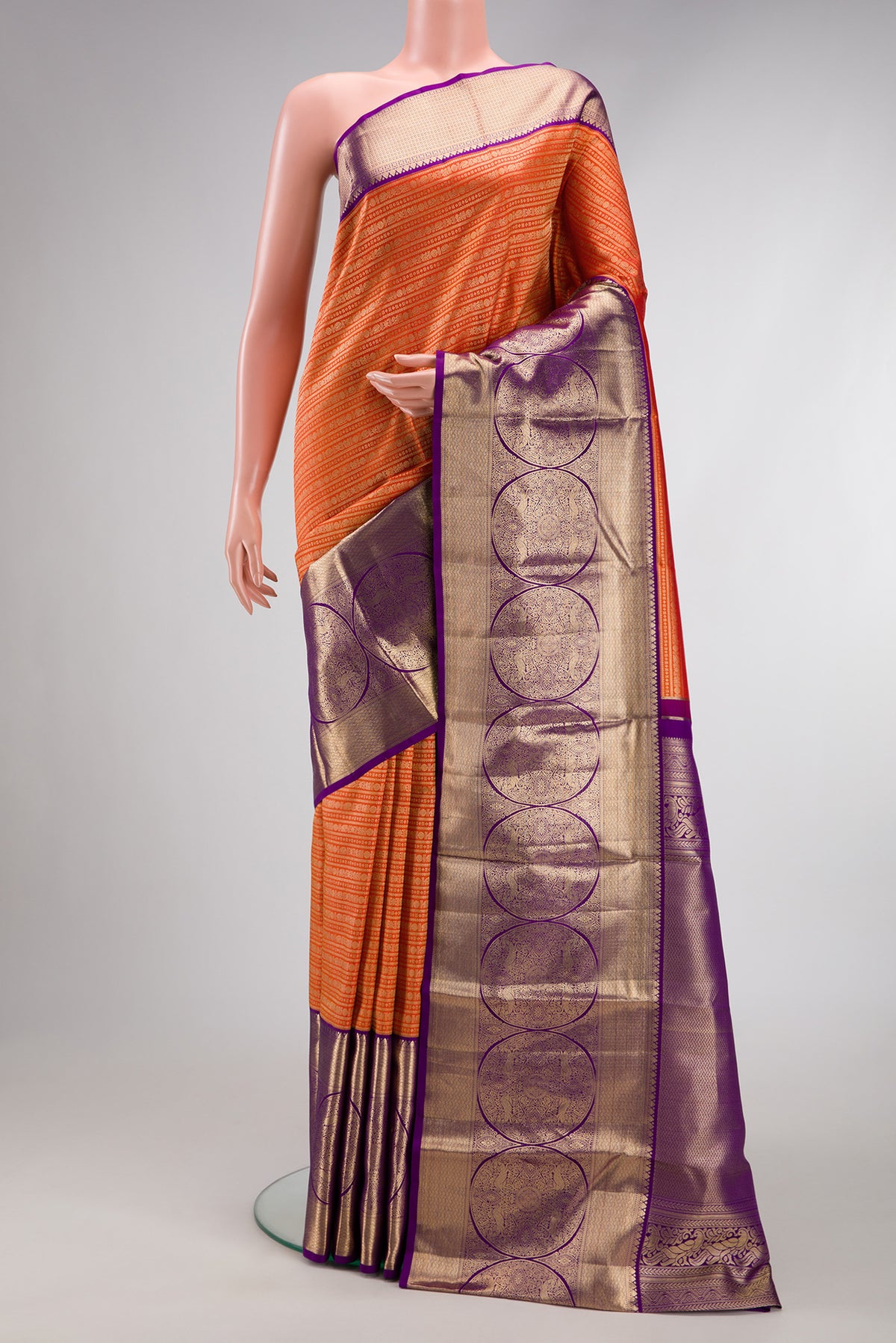 Orange Kanjivaram Silk Saree with Zari Brocade on the body and Zari Border.  displayed on a mannequin