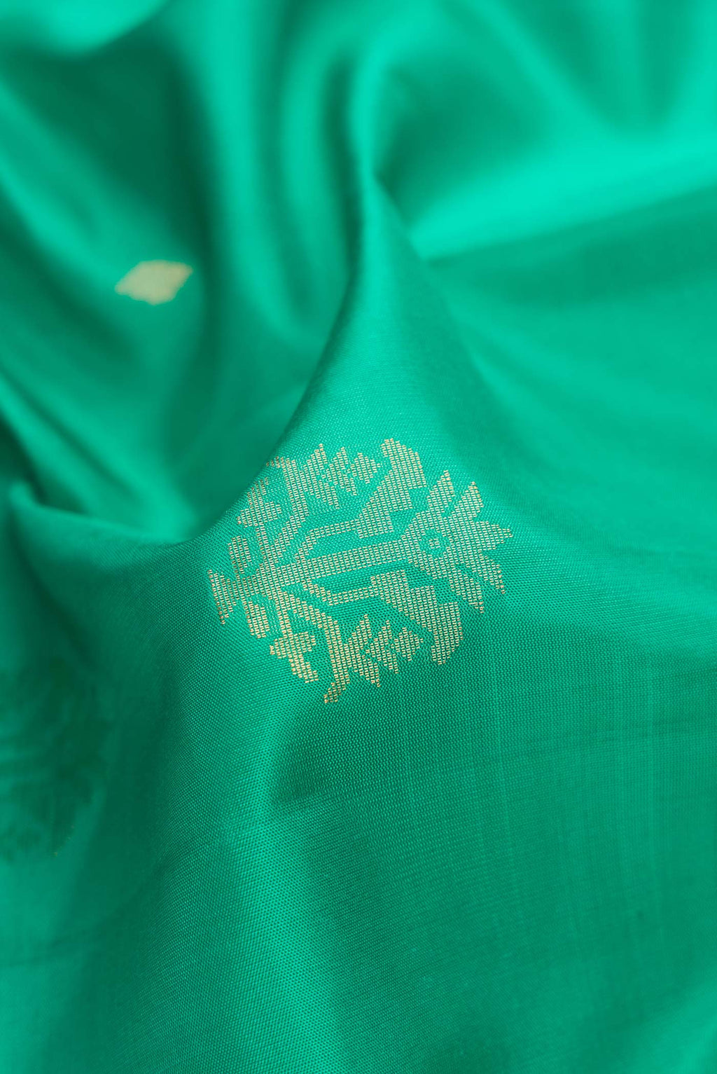 Close up of Sea Green Dual Tone Soft Silk Saree with Zari Butta on the body and Zari Border.  displaying folds