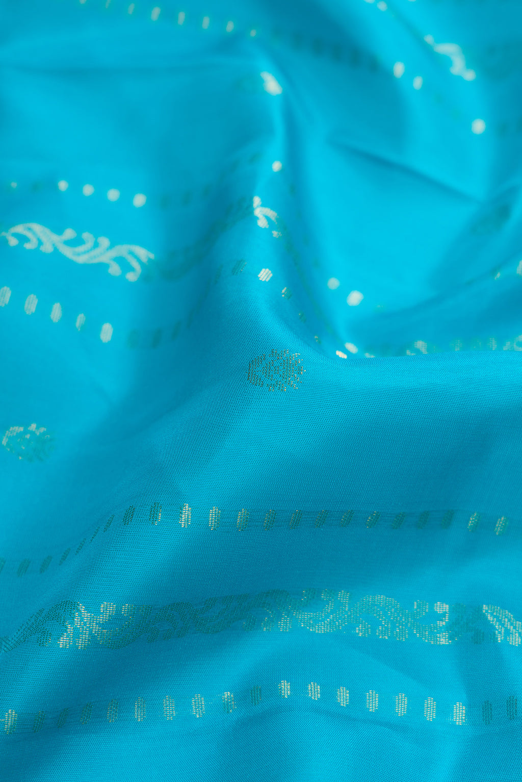 Close up of Sky Blue Dual Tone Soft Silk Saree with Zari Butta on the body and Zari Border.  displaying folds