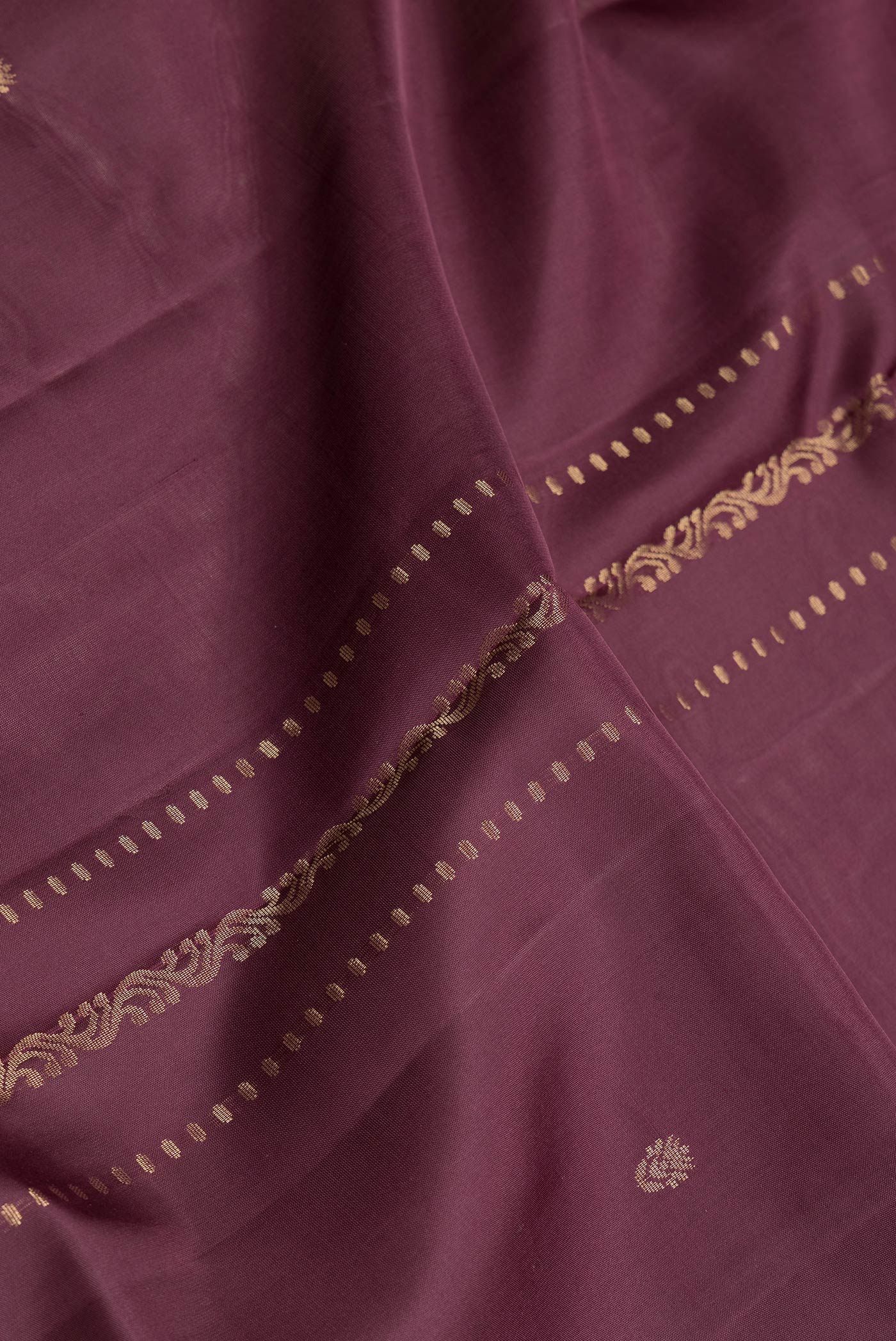 Close up of Maroon Dual Tone Soft Silk Saree with Zari Butta on the body and Zari Border.  displaying folds